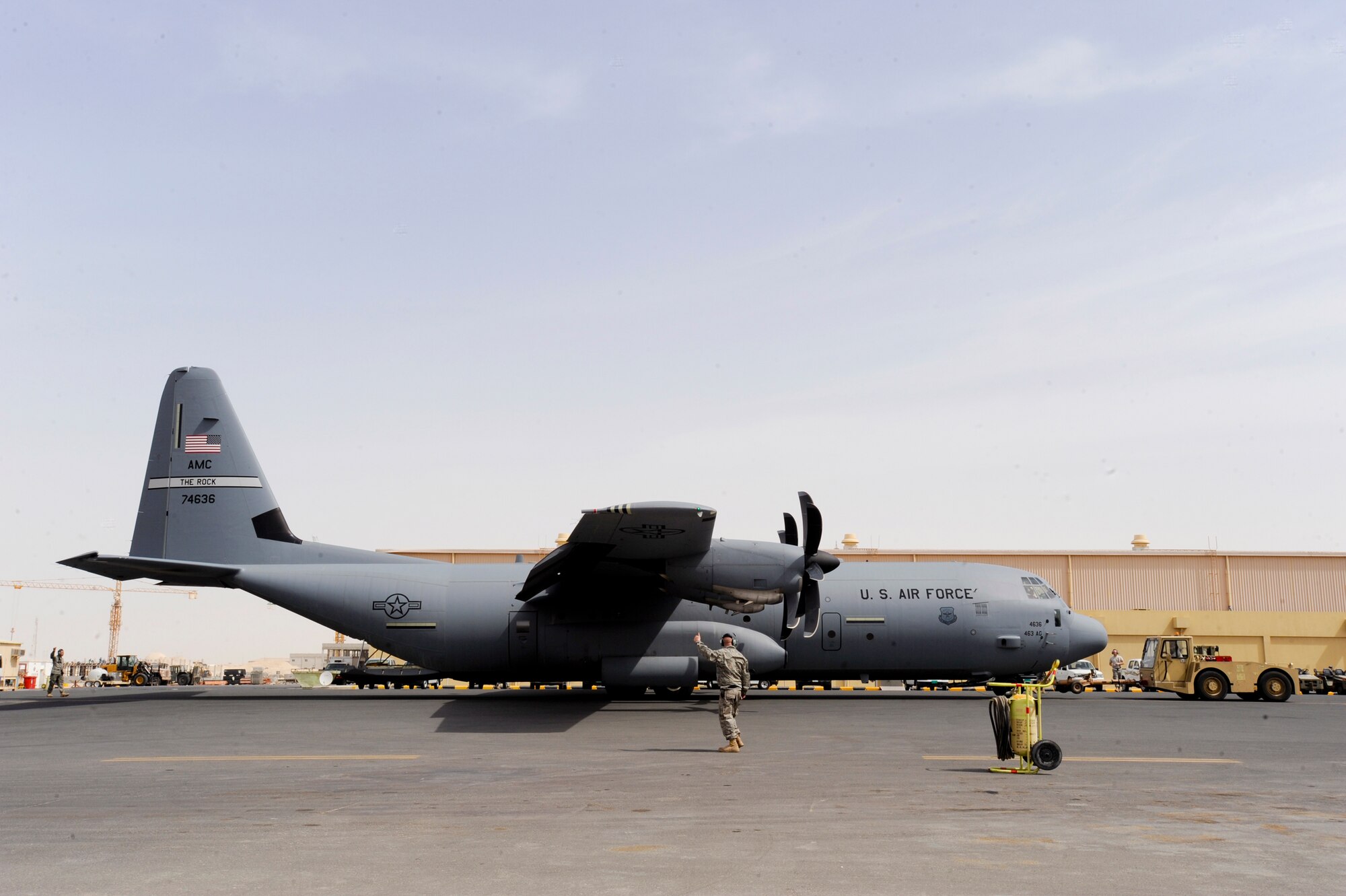A C-130J Hercules is towed into position by an aircraft tow, as crew chiefs watch for wingtip clearance, Feb. 12, 2009, in an undisclosed location in Southwest Asia.  The crew chiefs act as spotters to ensure nothing will come into contact with the aircraft way while it is being towed.  The C-130J is deployed from Little Rock Air Force Base, Ark. in support of Operations Iraqi and Enduring Freedom and Combined Joint Task Force - Horn of Africa.  (U.S. Air Force Photo by Staff Sgt. Joshua Garcia/released)
