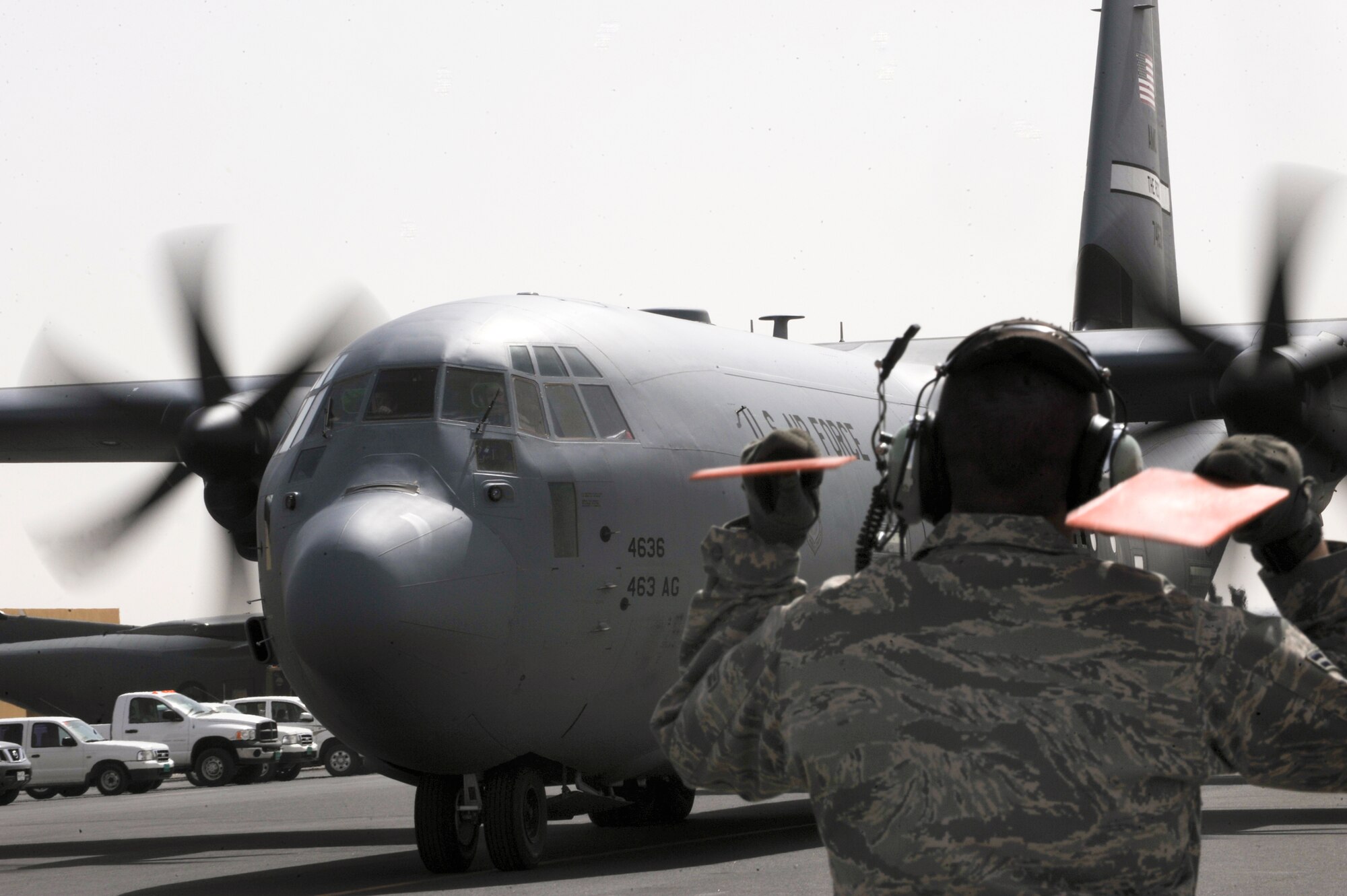 Airman 1st Class William Heptig, a crew chief with the 746th Aircraft Maintenance Unit, marshals a C-130J Hercules to a parking spot after returning from a mission, Feb. 12, 2009, in an undisclosed location in Southwest Asia. Without the ability to use audible instructions Airman Heptig uses signals to communicate with the pilot.  Airman Heptig is native to Prior Lake, Minn. and is deployed from Little Rock Air Force Base, Ark. in support of Operations Iraqi and Enduring Freedom and Combined Joint Task Force - Horn of Africa.  (U.S. Air Force Photo by Staff Sgt. Joshua Garcia/released)