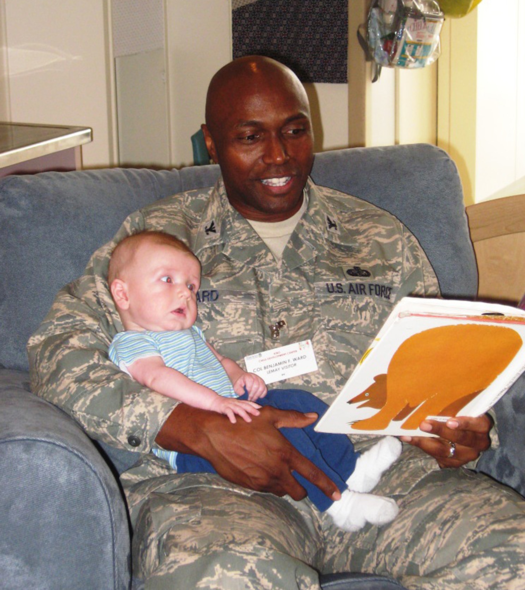 YOKOTA AIR BASE, Japan -- Col. Benjamin Ward, Air Force Gen. Curtis E. LeMay award evaluator, reads a book to Aden Smith at one of the Child Development Centers here. The evaluation team was here to judge the 374th Force Support Squadron facilities and services for the prestigious annual award. This award gives special recognition for excellence in programming and service. (Courtesy photo)