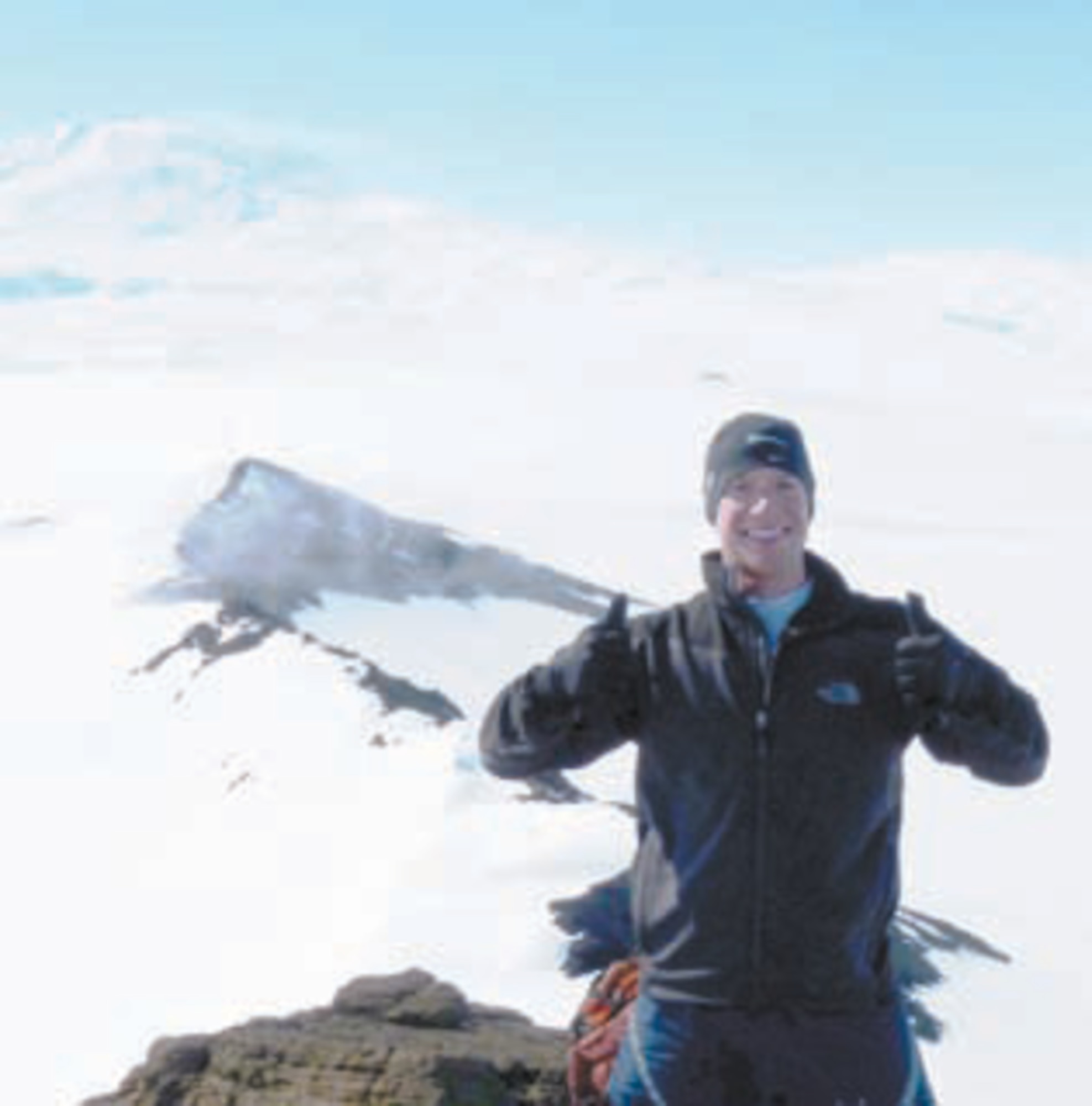 Air Force Academy Cadet 1st Class Patrick Warfel gives the thumbs up while standing on top of Caster Rock with the Mt. Erebus volcano in the background. (Courtesy photo)