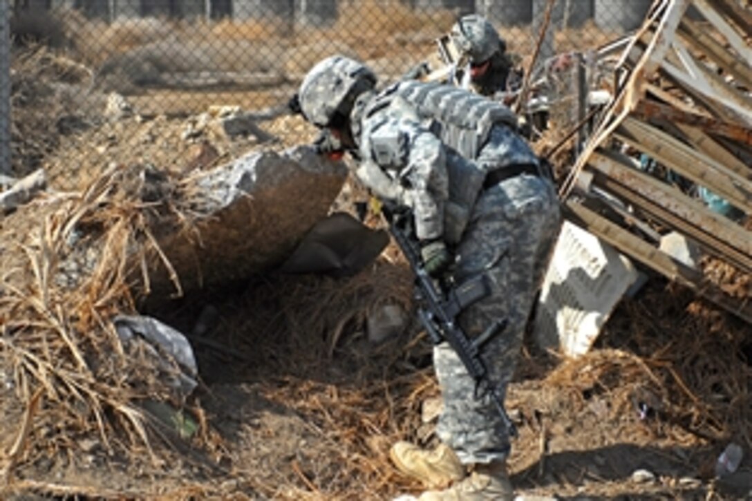 U.S. Army Staff Sgt. Eric Hummel searches for weapons caches in Ameriyah, Iraq, Feb. 7, 2009. Hummel is assigned to the 1st Infantry Division's 2nd Combat Brigade Team.