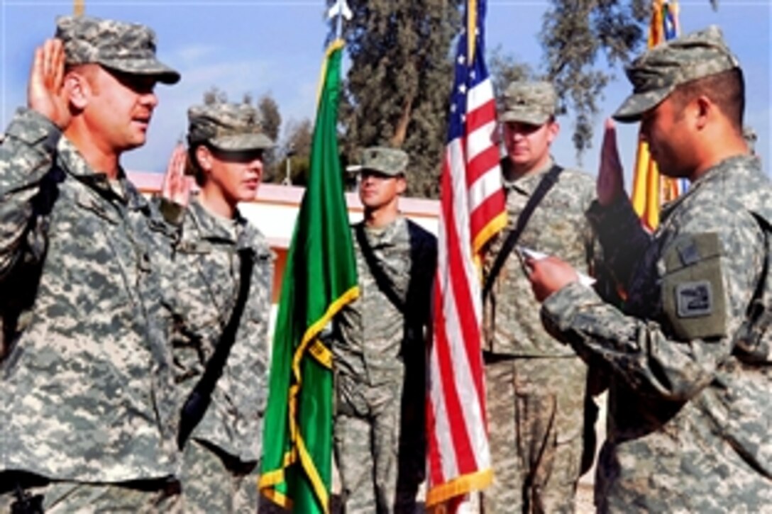 U.S. Army Sgts. Mathew, left, and Emily Suhr, who are husband and wife are re-enlisted by their company commander, 1st Lt. Buddy Francisco, in a ceremony on Camp Ramadi, Iraq, Feb. 13, 2009. The Suhrs are assigned to Headquarters 81st Brigade Combat Team, Washington Army National Guard. In addition to re-enlisting, the couple has volunteered to stay in Iraq after their brigade goes home.  