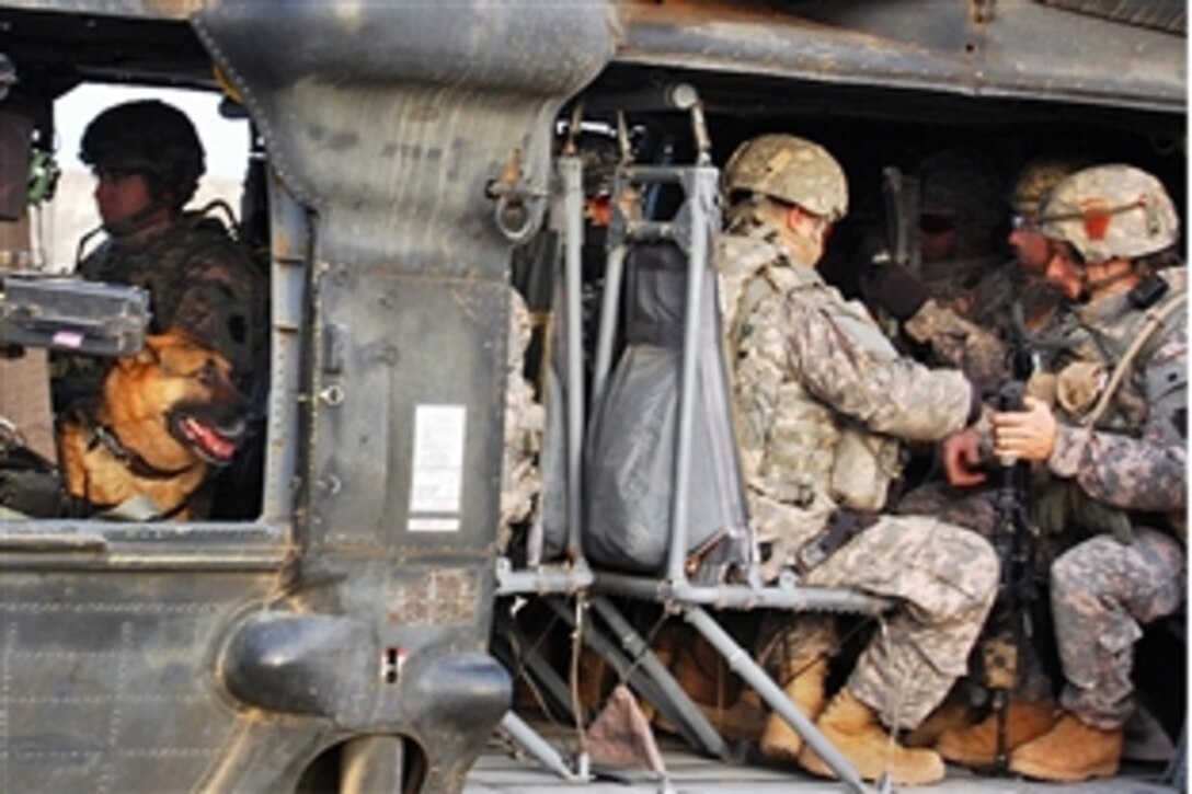Piero, a military working dog looks on from the gunner's window of an UH-60 Black Hawk helicopter during loading procedures on Joint Security Station Istaqlal, Feb. 15, 2009. The soldiers are assigned to the 56th Stryker Brigade Combat Team. Piero trains with other soldiers and their Iraqi security force partners on air-assault operations in areas north of Baghdad.