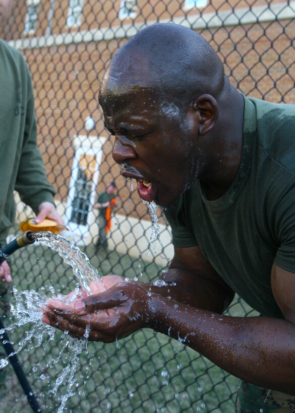 Cpl. Lorenzo Williams, Body Bearer, Bravo Company, Marine Barracks Washington, vigorously washes OC spray from his face during nonlethal tactics training at Marine Barracks Washington, Feb. 17. Marines qualified as users and instructors of oleoresin capsicum.