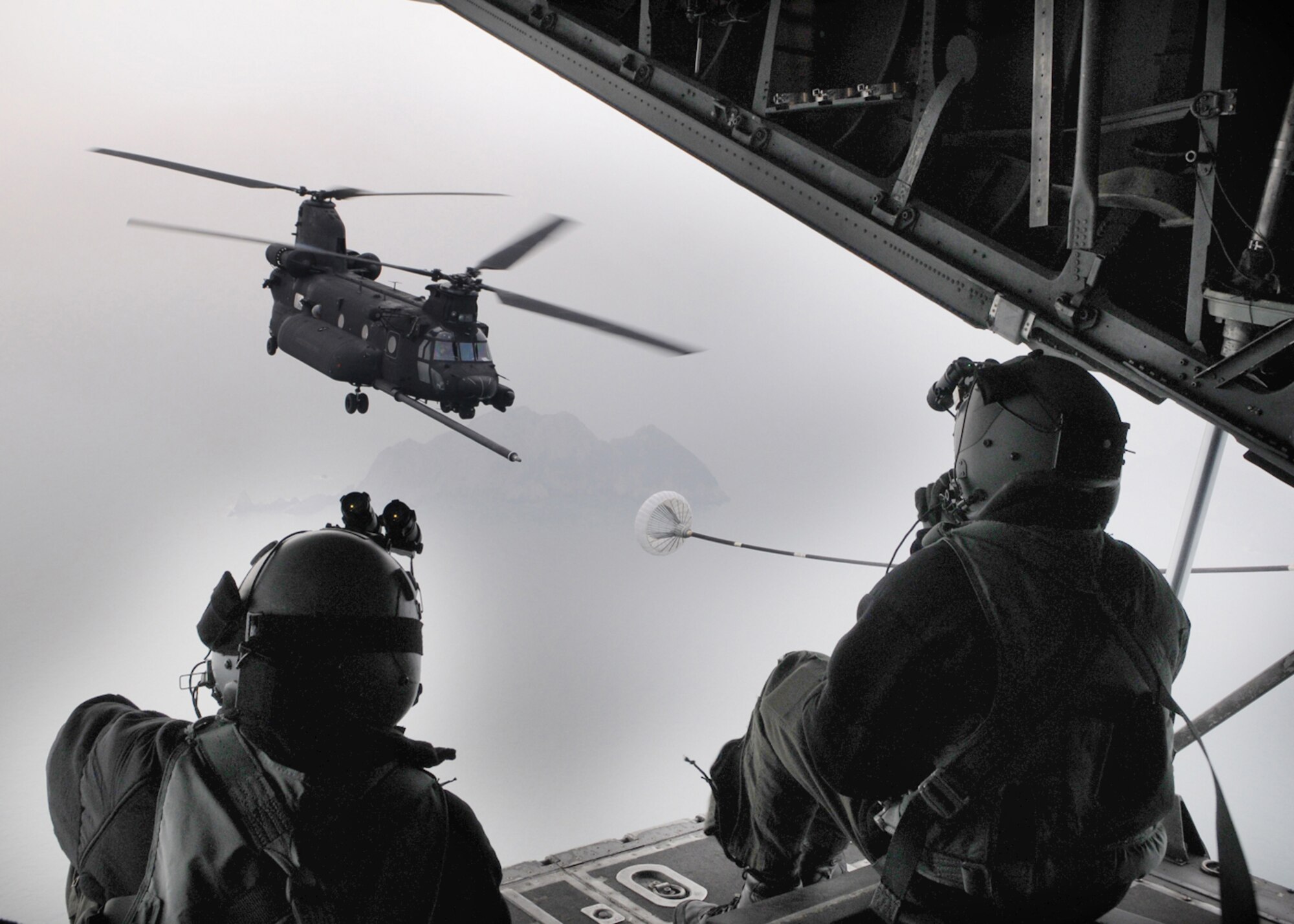 OSAN AIR BASE, Republic of Korea -- Senior Airman Meagan Freeman (left) and Airman 1st Class Jed Bilibei, both loadmasters with the 17th Special Operations Squadron, send signals from the back of a MC-130P Combat Shadow to the crew of a U.S. Army MH-47 helicopter from the 160th Special Operations Aviation Regiment (Airborne) during an aerial refueling mission near the Korean peninsula Feb. 12. Sixteen members from the 17th SOS, the 353rd Special Operations Group Forward Area Refueling Point Team, 353rd Maintenance Squadron and Detachment 3 of 25th Intelligence Squadron, conducted training in the Republic of Korea Feb. 9 - 12 to ensure they are ready to fulfill their duties as the only Air Force special operations unit permanently assigned in the U.S. Pacific Command theater. (U.S. Air Force photo by Tech. Sgt. Aaron Cram)