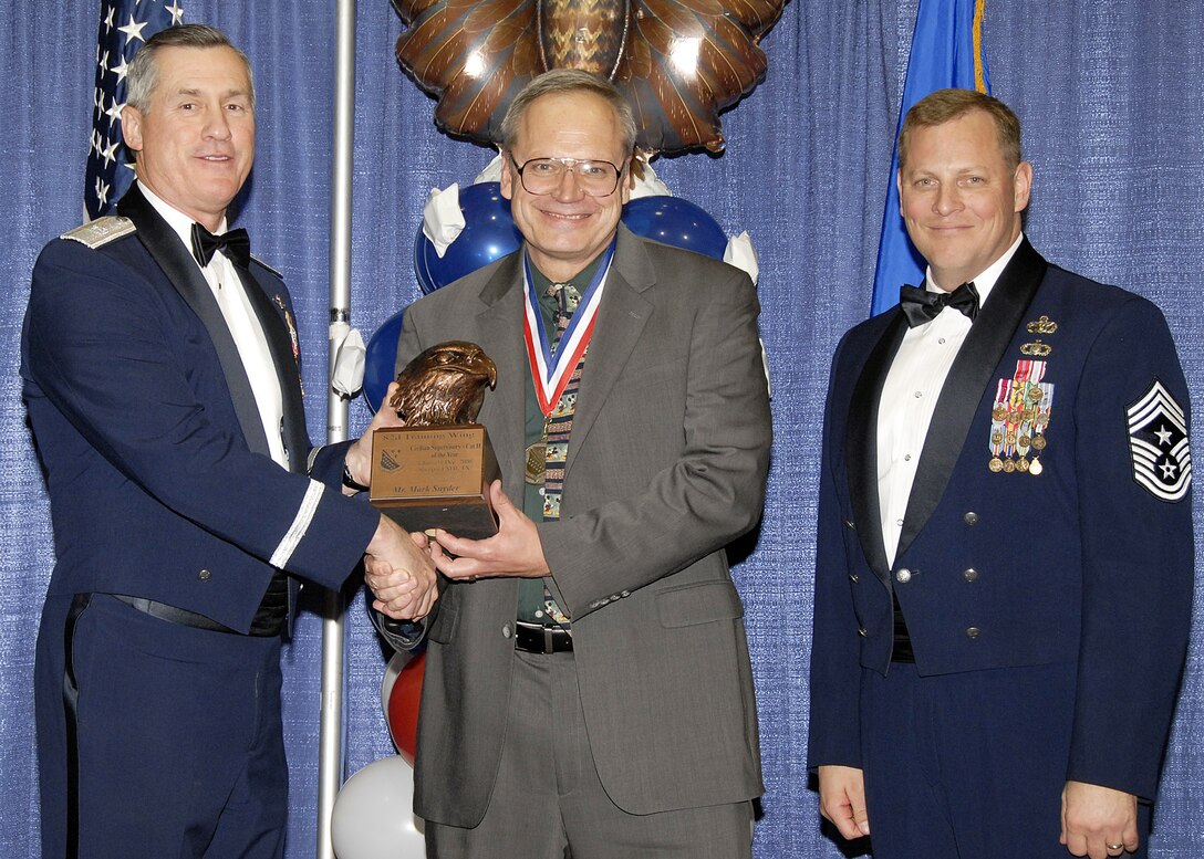 Mark Snyder, 82nd Mission Support Group, accepts the Suppervisory Civilian of the Year, Catagory II award on Feb. 13 from 82nd Training Wing Commander Brig. Gen. O.G. Mannon during the Annual Awards Banquet at the Multi Purpose Event Center. Also pictured is 82nd TRW Command Chief Master Sgt. Kenneth Sallinger. (U.S. Air Force photo/Lou Anne Sledge) 