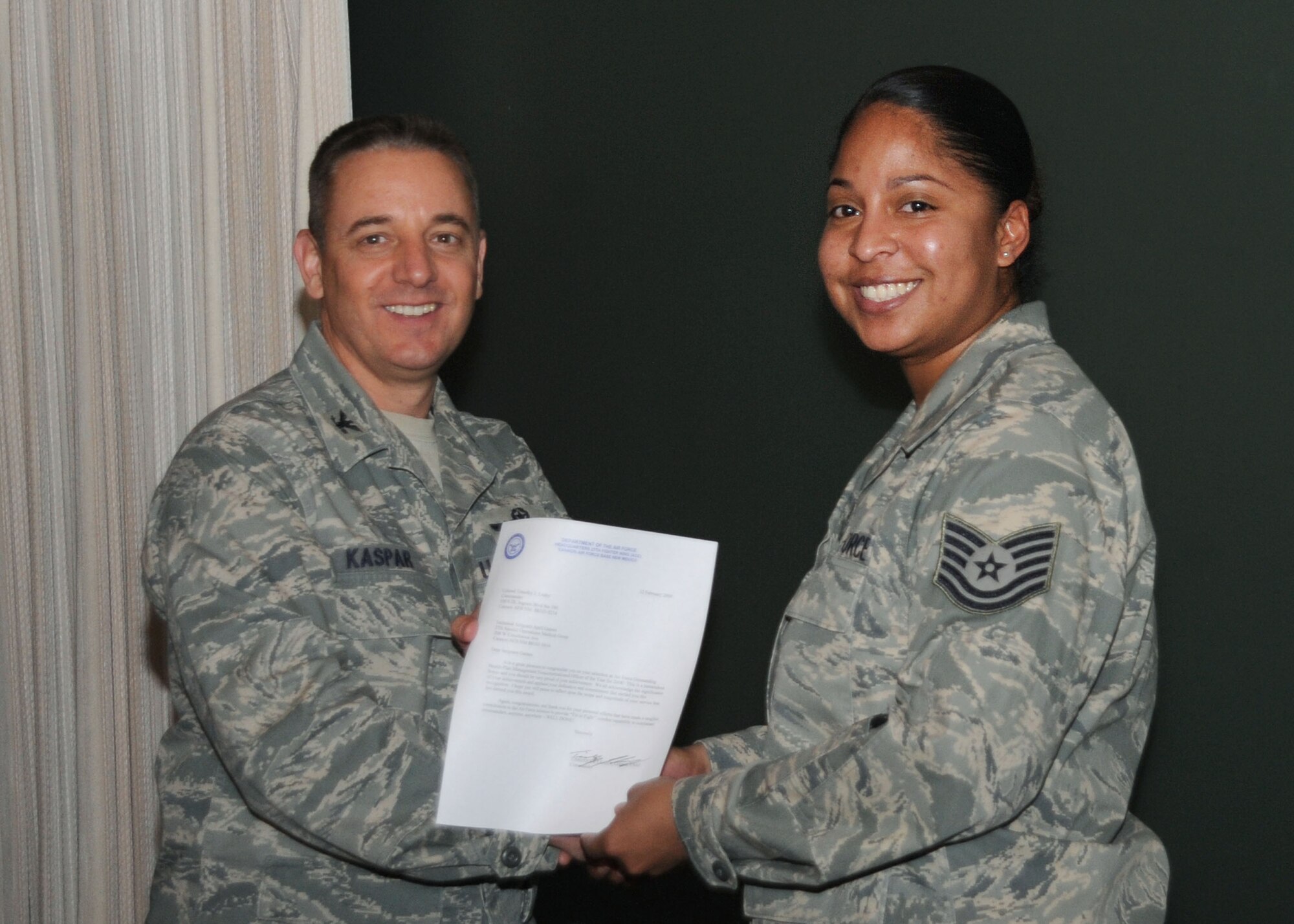 CANNON AIR FORCE BASE, N.M.-- Col. Hans Kaspar, 27th Special Operations Wing vice commander, awards Tech. Sgt. April Gaines, 27th Special Operations Medical Support Squadron, the  2008 United States Air Force Outstanding Health Plan Management Non-Commissioned Officer of the Year award Feb 17. Sergeant Gaines was presented the award at the weekly wing staff meeting. (U.S. Air Force photo by Airman 1st Class Maynelinne De La Cruz)