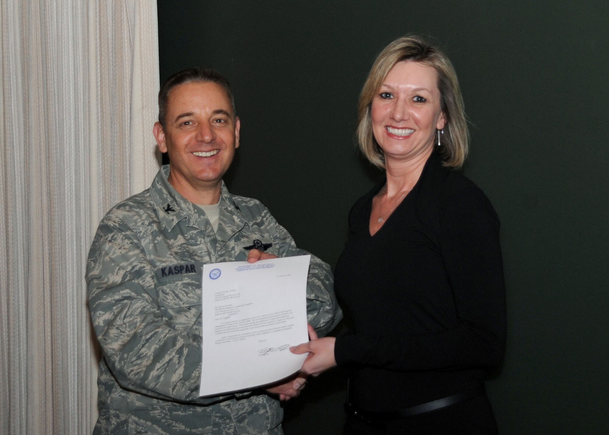 CANNON AIR FORCE BASE, N.M.-- Col. Hans Kaspar, 27th Special Operations Wing vice commander, presents Sharon Winnicki, 27th Special Operations Comptroller Squadron, the 2008 United States Special Operations Command Financial Management Civilian of the Year award Feb 17. Ms. Winnicki was presented the award at the weekly wing staff meeting. (U.S. Air Force photo by Airman 1st Class Maynelinne De La Cruz)  