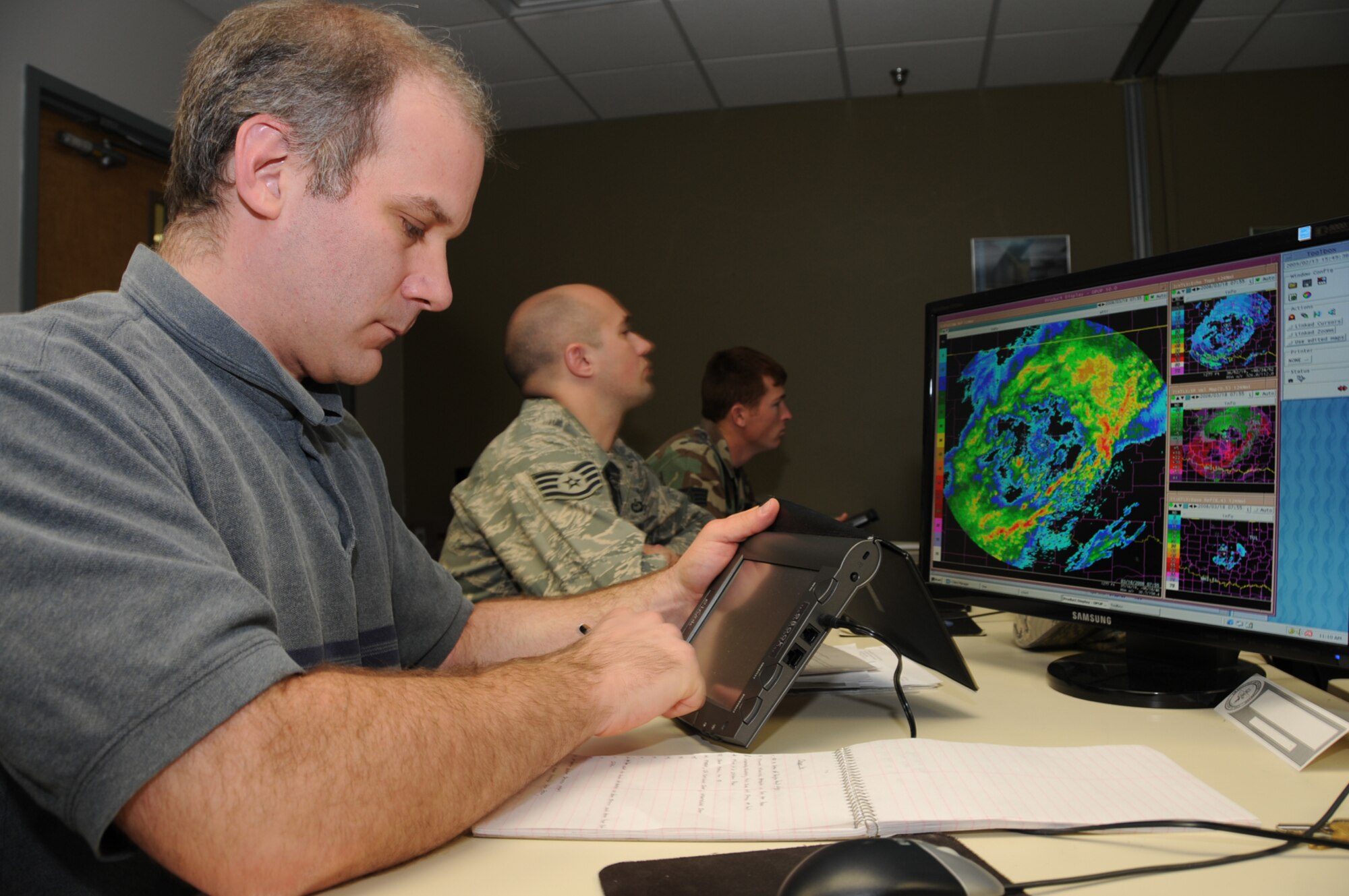 From left, Matthew Albertson and Staff Sgts. Brandon Healy and Jeffrey Hunter, students in the 335th TRS, use e-Books in the WSR-88D doppler weather operator manager’s course in the weather training complex Friday.  (U.S. Air Force photo by Kemberly Groue)
