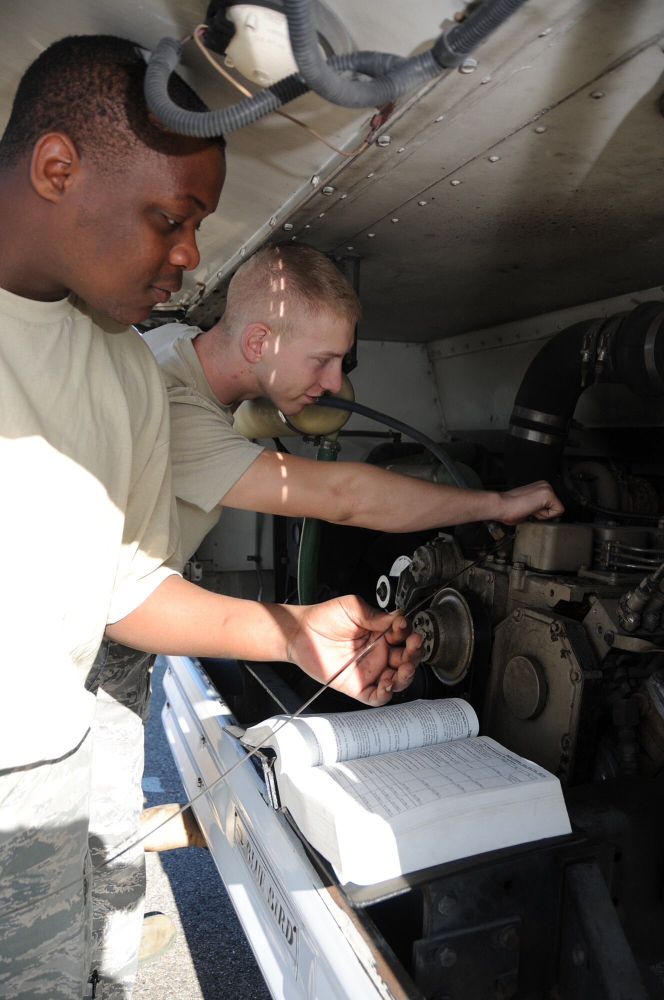 Airmen Daniel McLaurin, left, and Clyde Hale, 81st Logistics Readiness Squadron do a fluid check on a bus in preparation for next week’s visit by Air Education and Training Command’s Logistics Standardization and Evaluation Team.  (U.S. Air Force photo by Kemberly Groue)