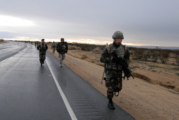 Airman 1st Class Joseph Lahman (front), 95th Security Forces Squadron patrolman, runs down the Rosamond Boulevard as part of the Joyner Invitational challenge Feb. 16. (Air Force photo by Senior Airman Julius Delos Reyes)