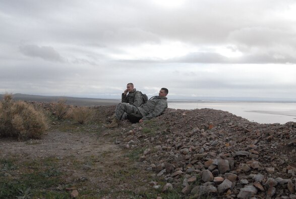 Two 95th Security Forces Squadron Airmen rest after embarking on a 9.1-mile march from the West Gate to Red Hill during the 2nd Joyner Invitational Feb. 16. (Air Force photo by Senior Airman Julius Delos Reyes)