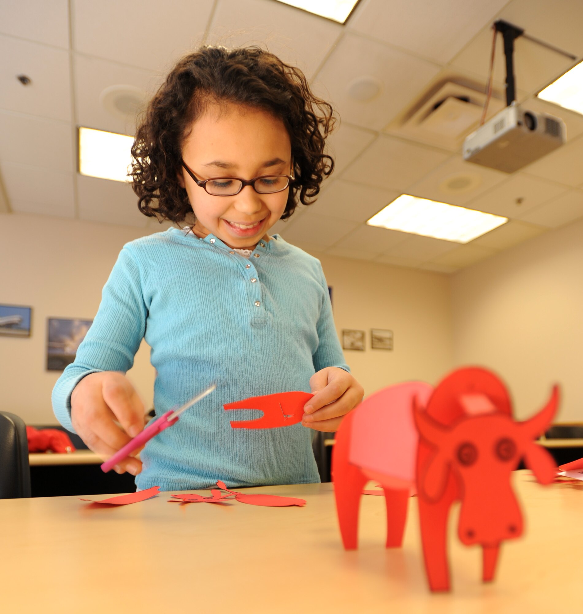 MCCONNELL AIR FORCE BASE, Kan. -- Mari Vechery, 10, daughter of Col. James Vechery, 22nd Air Refueling Wing commander, cuts out pieces of construction paper for an art project at the School Age Book Club held by the McConnell Library, Feb 5. The School Age Book Club is designed to enhance children’s reading abilities through various activities like reading chapters of a book, then listening to the audio of those chapters while working on crafts. The program is scheduled throughout the school year with other supporting programs during the summer. (Photo by Senior Airman Roy Lynch) 