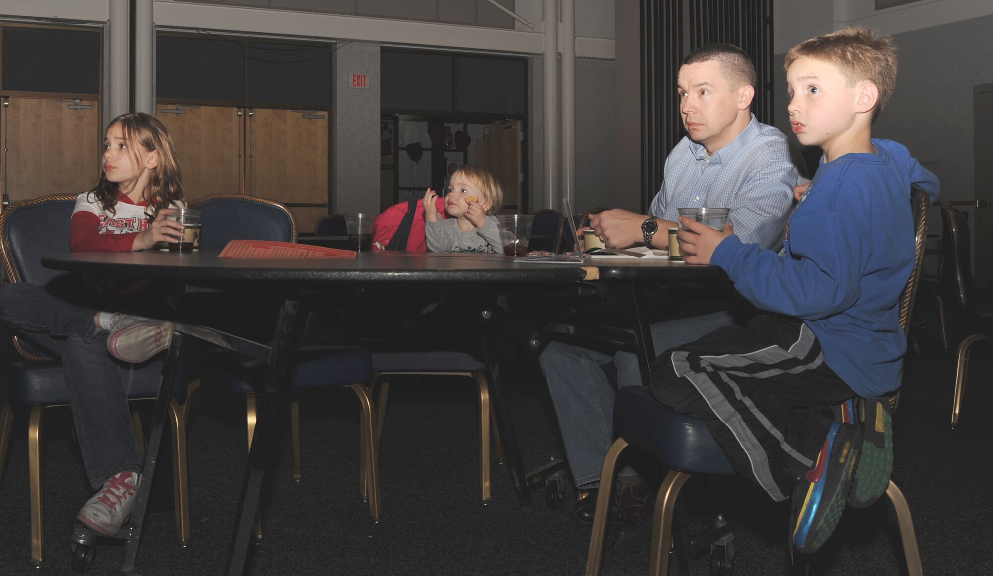 MCCONNELL AIR FORCE BASE, Kan. -- Army Capt. William Vanfleet, 425th Transportation Company, and his children Ashley, Cloe and Bryce enjoy all-you-can-eat chili while watching 1931’s Dracula during Classic Scary Movies on the Big Screen at the Robert J. Dole Community Center, Feb. 13. (Photo by Airman 1st Class Maria Ruiz)