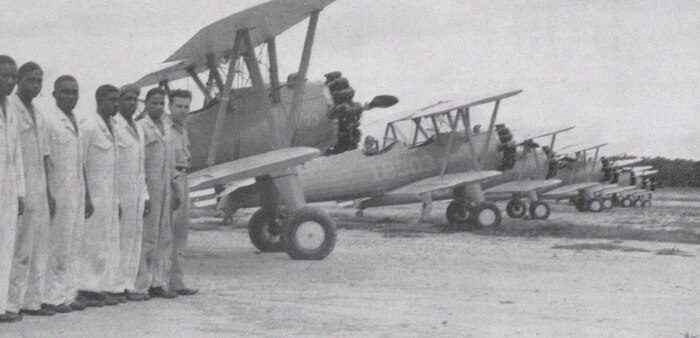 Tuskegee Airmen form up on the flight line in Tuskegee, Ala. in front of of Boeing Stearman PT-13s, during World War II. The Army Air Corps used the Stearmans as a primary trainer to teach fledging pilots basic flying skills before they moved onto higher-performance aircraft. 
(courtesy photo)