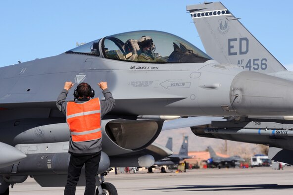 Maj. Scott Mclaren, 416th Flight Test Squadron pilot, pays attention for directions from Alfonso Duran, production supervisor with the 416th FLTS, during Red Flag at Nellis Air Force Base, Nev., Feb. 4. This is the first time an Air Force Materiel Command unit has ever deployed and participated in the exercise. (Air Force photo by Airman First Class Brett C. Clashman)
