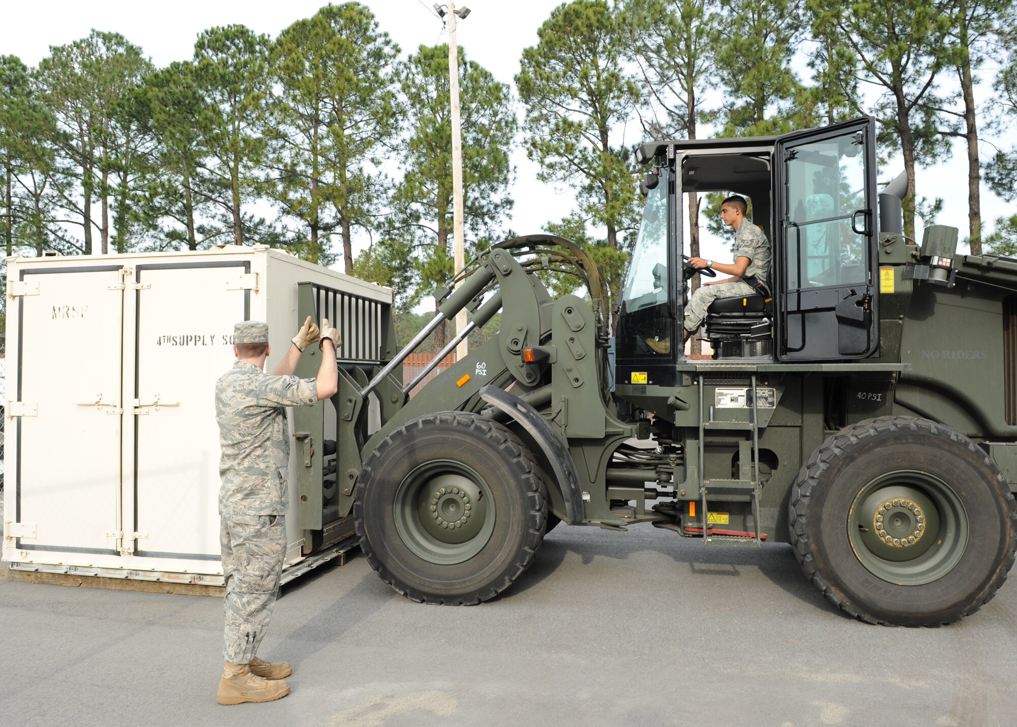Airman 1st Class Zachary Mayo directs Airman 1st Class Anthony Padilla, both from the Combat Vehicle Operations Flight here, in backing up the forklift on Seymour Johnson Air Force Base, N.C., Feb. 11, 2009. Airman Mayo acts as eyes for Airman Padilla who cannot see the forks below. (U.S. Air Force photo by Airman 1st Class Whitney Stanfield)
