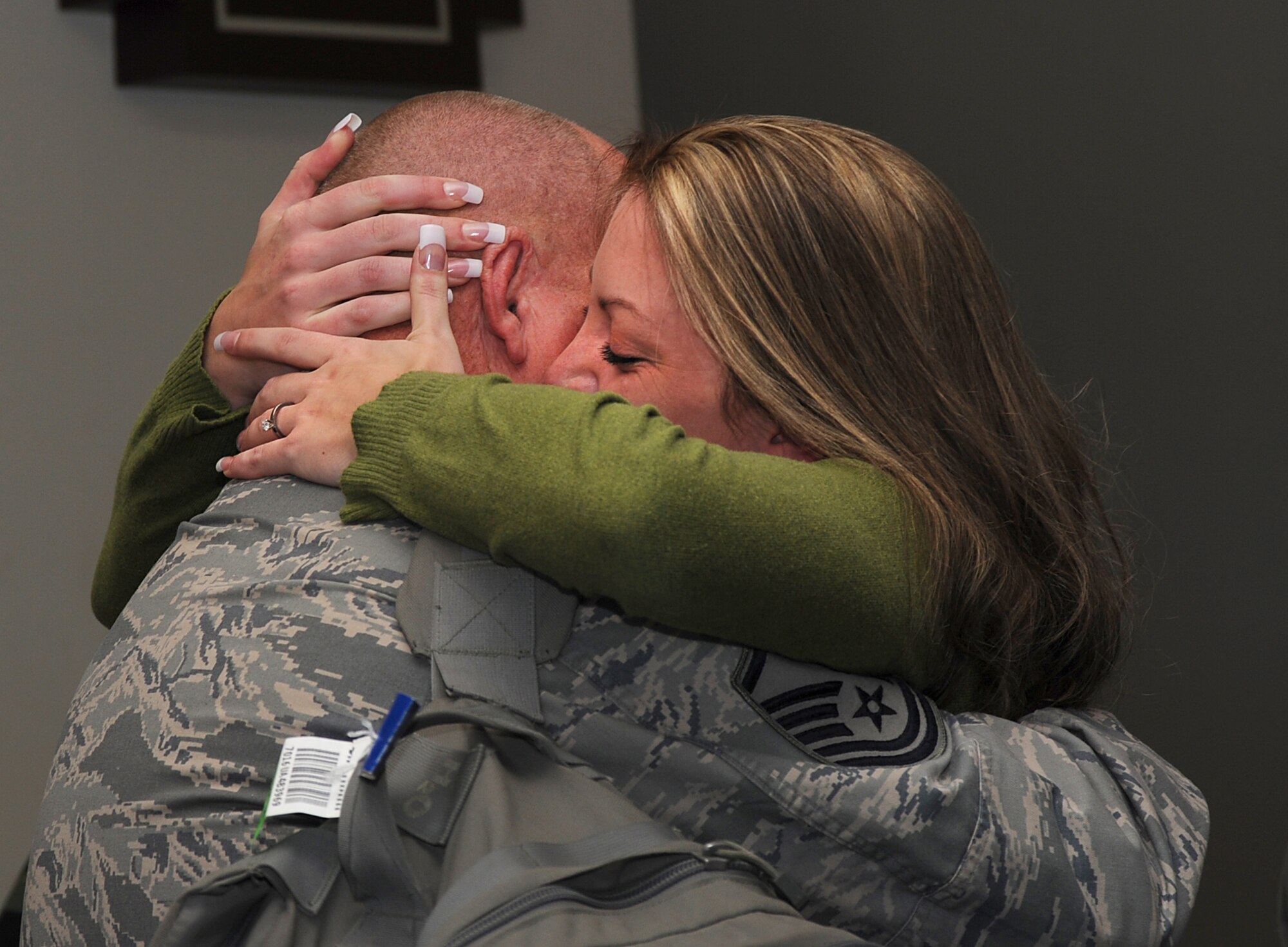 COLORADO SPRINGS, Colo. -- Ashley Frost bear hugs her husband Master Sgt. Scott Frost for the first time after eight months of being separated. The first group of  Air Force Reserve Security Forces Airmen from the 310th Security Forces Squadron, Schriever Air Force Base, Colo., the 710th Security Forces Squadron, Buckley AFB, Colo., and the 302nd Airlift Wing, Peterson AFB, returned to Colorado Springs this week after an eight-month deployment to Iraq.  They were greeted at Colorado Springs Airport Monday morning to a large crowd of friends and family. (US Air Force photo/Amber K. Whittington)