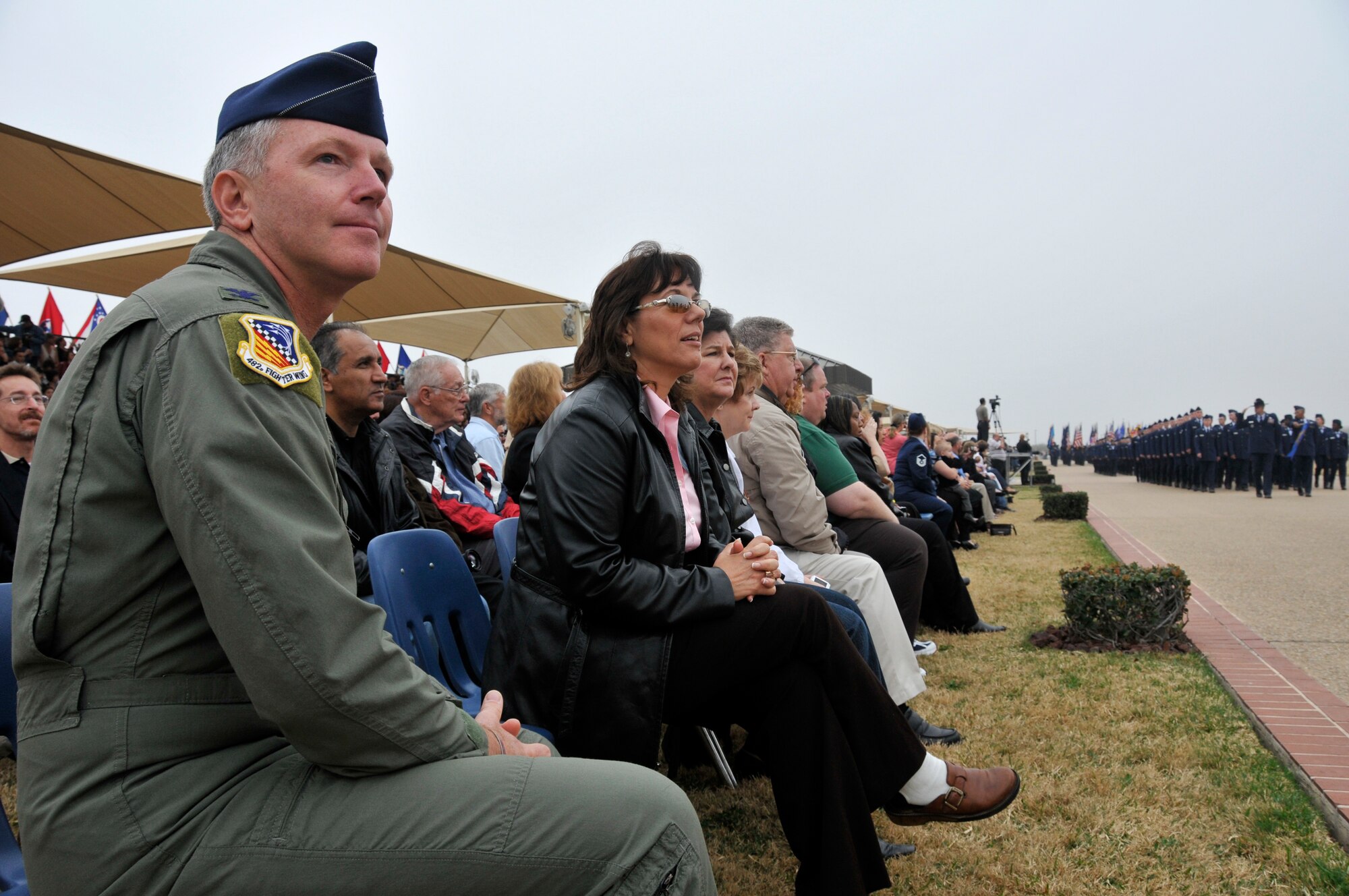 Col. William Binger, 482nd Fighter Wing commander, and City of Homestead Mayor Lynda Bell, watch Airmen “pass in review” during a Basic Military Training graduation parade at Lackland AFB, Texas, on Feb. 13.  Thirty five influential leaders from the Miami area boarded a KC-135 Stratotanker for a two-day “Civic Leader Flight” to Keesler AFB, Miss., and Lackland AFB, Texas, on Feb. 12-13. (U.S. Air Force photo/Tim Norton)