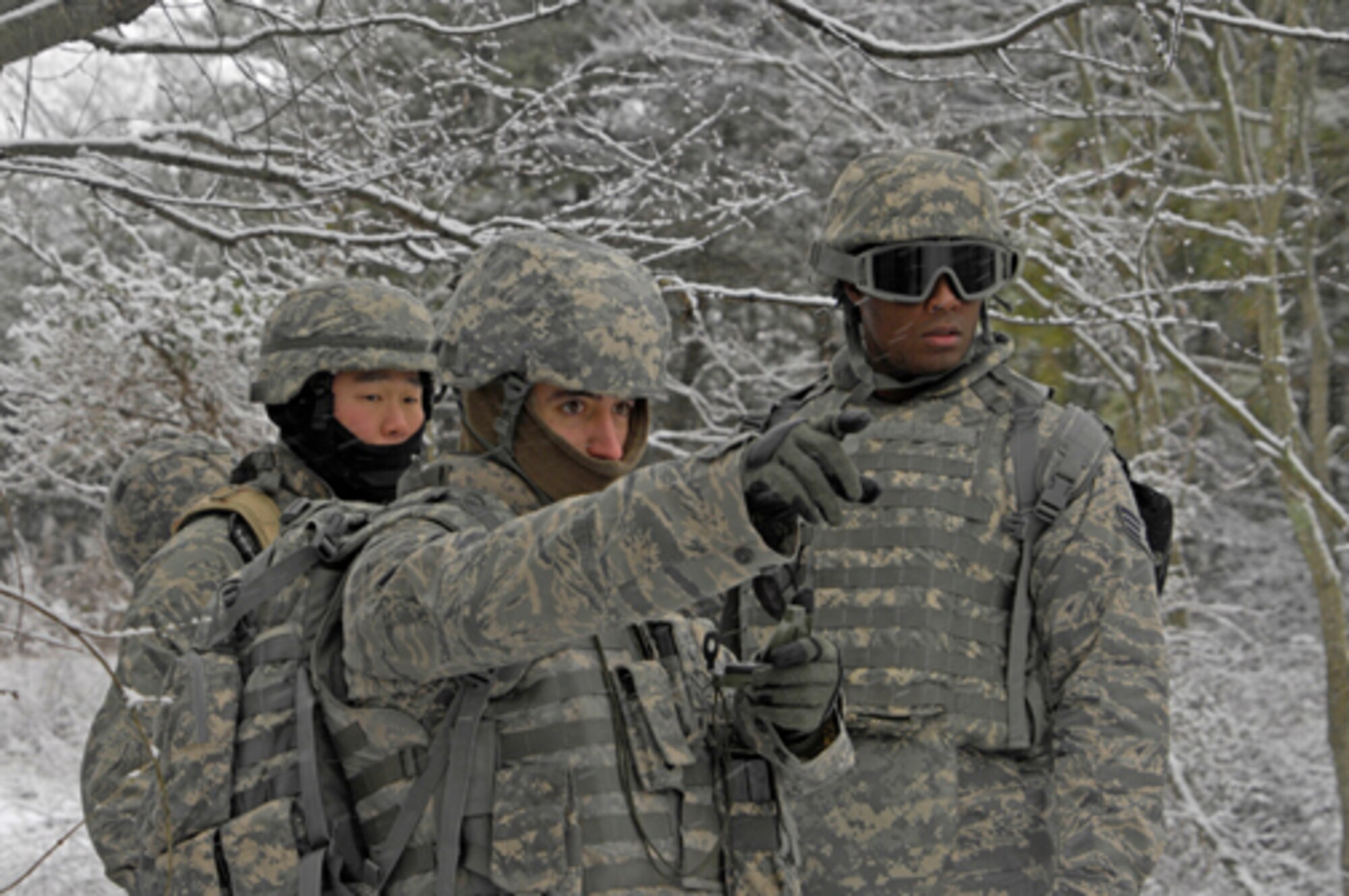 Staff Sgt. Jason Ventura and Senior Airman Rashad Stafford watch while Airman 1st Class Jesse Christensen indicates the direction they should take after he checked the azimuth recently at Fort Dix. The Alpha 6 team was training in land navigation to prepare for a deployment. (U.S. Army photo/Lisa Evans) 