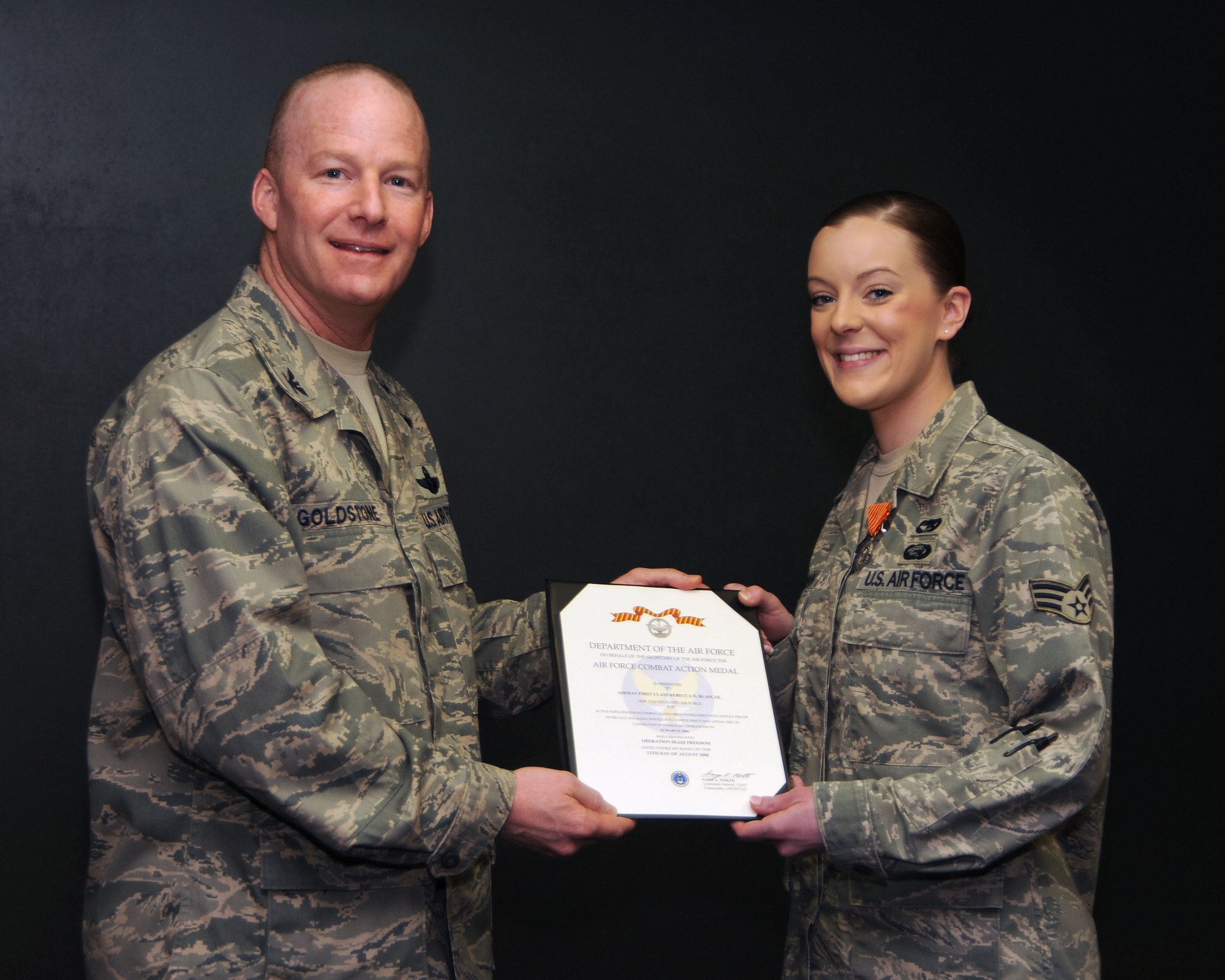 SCOTT AIR FORCE BASE, Ill. -- Senior Airman Rebecca Hagerman, 375th Mission Support Squadron, lead customer service technician, receives her Combat Action Medal from 375th AW commander Col. Gary Goldstone at the Wing All Call last Thursday. (U.S. Air Force photo/Airman 1st Class Wesley Farnsworth) 