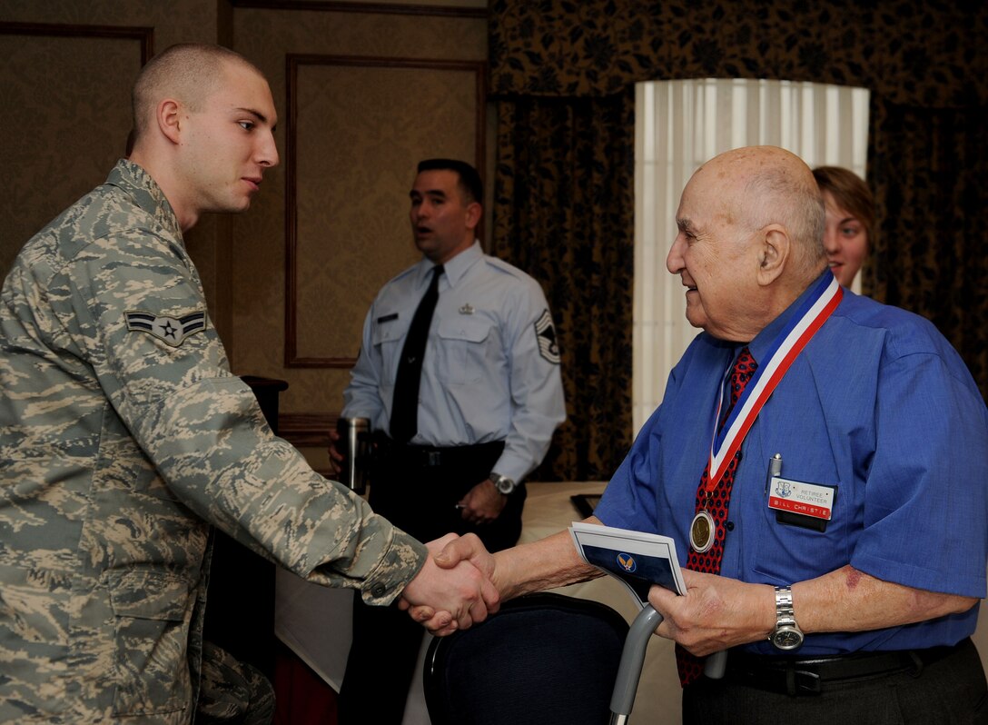 LANGLEY AIR FORCE BASE, Va. -- Retired Chief Master Sgt. Gabriel W. "Bill" Christie, a Charter Chief, shakes hands with  Airman 1st Class Jonathan Chrismon, 1st Equipment Maintenance Squadron, during a Heritage of Enlisted Leadership ceremony Feb. 18. The Charter Chiefs were the first 625 chief master sergeants promoted to the newly created rank under the Career Compensation Act of 1958. (U.S. Air Force photo/Airman Rebecca Montez)