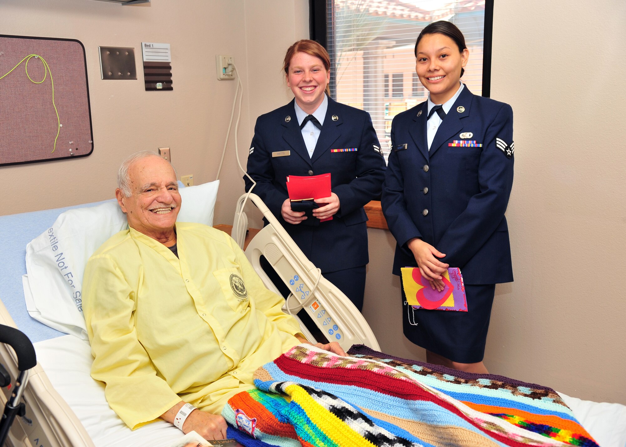Senior Airman Trisha Norris (right) and Airman 1st Class Stacey Watts from the 355th Force Support Squadron pose for a photo with Stan Jampole after visiting with patients during the 34th Annual National Salute to hospitalized Veterans at the VA hospital in Tucson, Feb. 11. (U.S. Air Force photo/Senior Airman Noah R. Johnson)