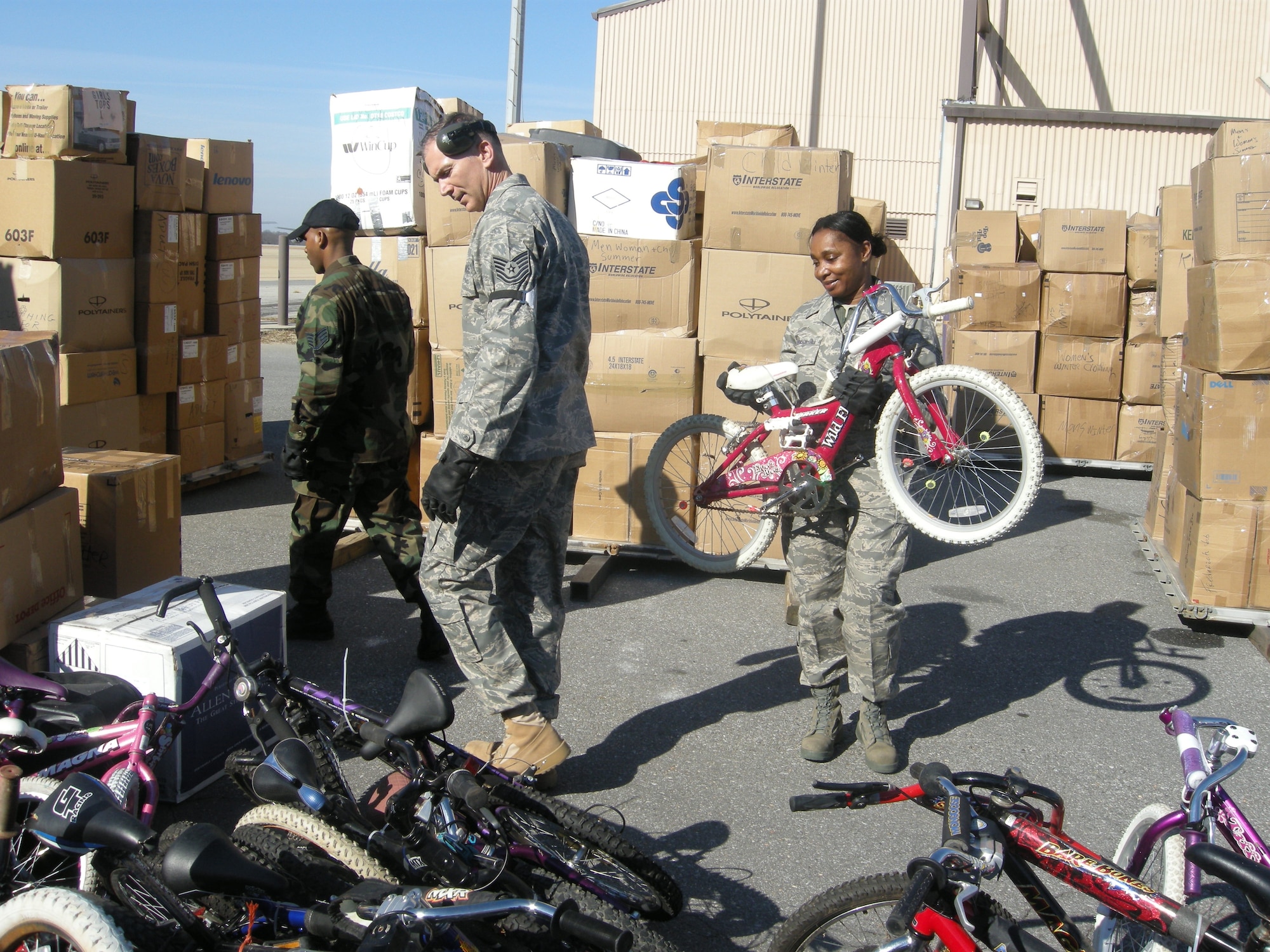 ANDREWS AIR FORCE BASE, Md. -- (From left) Staff Sgt. Darryl Jordan and Tech. Sgts. Jerry Trickett and Karen Robinson-Hill stack bicycles to load on pallets  Feb. 7. About 20 members of the 69th Aerial Port Squadron loaded more than 16 pallets of school supplies, clothing, toys and tools to be sent to Aschiana School in Kabul, Afghanistan, as part of "Opportune Airlift." Cargo is moved through the Defense Transportation System on a space-available basis by air, surface, sea or a combination thereof for the purpose of ongoing relief and development projects. Sergeant Jordan is a 69th APS air transportation journeyman and Sergeants Trickett and Robinson-Hill are air transportation craftsmen. (U.S. Air Force photo/Tech. Sgt. Amaani Lyle)