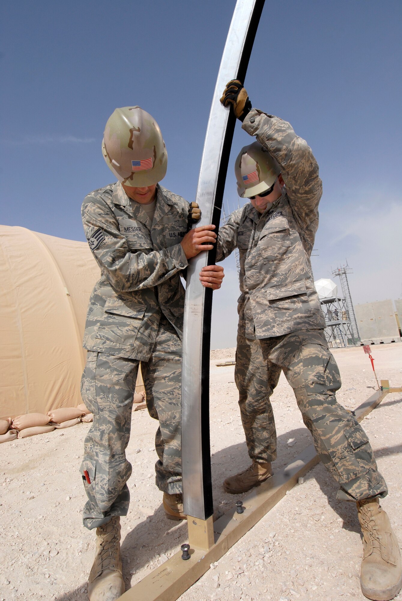 Staff Sergeant James Messer and Senior Airman Geoffrey Witte, 379th Expeditionary Civil Engineer Squadron Structural Craftsman, work an arch into the base of a California Medium Shelter System (CAMSS) used to house Airmen, Feb. 17, 2009 at an undisclosed location in Southwest Asia.  Staff Sgt. Messer hails from Murphy, N.C. and is deployed from Scott Air Force Base, Ill.  Senior Airman Witte hails from Anadarko, Okla. and is deployed from Vandenberg Air Force Base, Calif.  Both are deployed in support of Operations Iraqi and Enduring Freedom and Combined Joint Task Force - Horn of Africa.  (U.S. Air Force photo/Airman 1st Class Andrew Satran/released)