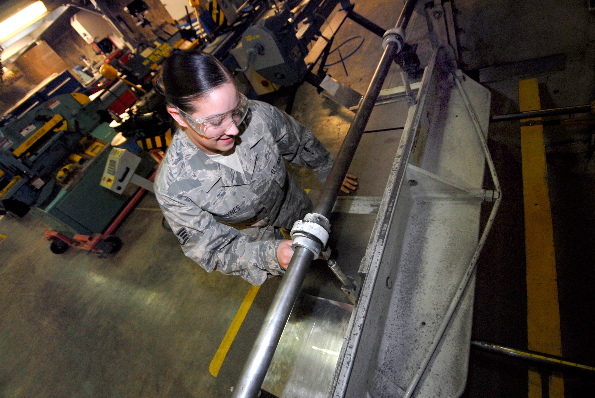 Staff Sergeant Michelle Haynes, a 379th Expeditionary Maintenance Squadron Aircraft Structural Maintenance Craftsman, cuts a piece of sheet metal for a project in the fabrication shop, Feb. 17, 2009, at an undisclosed location in Southwest Asia.  Staff Sgt. Haynes hails from Poughkepsie, N.Y. and is deployed from Little Rock Air Force Base, Ark. in support of Operations Iraqi and Enduring Freedom and Combined Joint Task Force - Horn of Africa.  (U.S. Air Force Photo by Airman 1st Class Andrew Satran/Released)