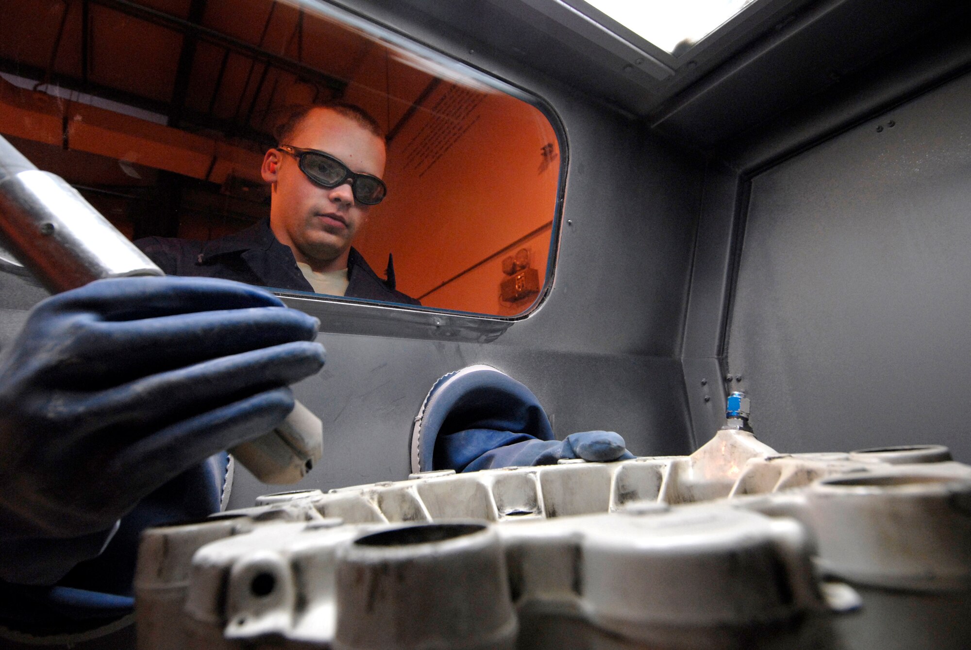Senior Airman Scot Peck, a 379th Expeditionary Maintenance Squadron Aircraft Structural Maintenance Journeyman, prepares to blast the paint off of a brake housing in the media blaster box, Feb. 17, 2009, at an undisclosed location in Southwest Asia.  Senior Airman Peck hails from Tacoma, Wash. and is deployed from McCord Air Force Base, Wash. in support of Operations Iraqi and Enduring Freedom and Combined Joint Task Force - Horn of Africa.  (U.S. Air Force photo/Airman 1st Class Andrew Satran/released)