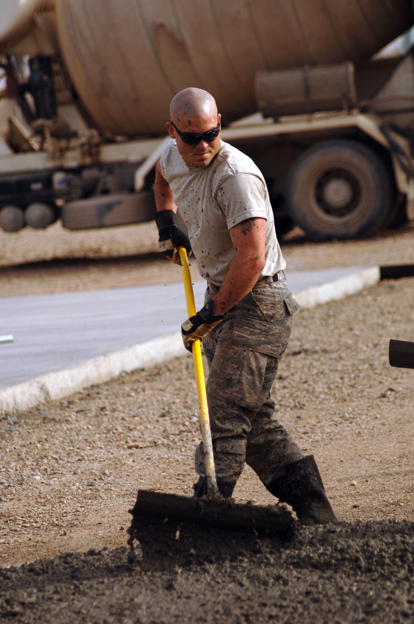JOINT BASE BALAD, Iraq - Staff Sgt. Jason Hopper, 332nd Expeditionary Civil Engineer Squadron pavement and construction equipment operator, evenly spreads out  a mound of concrete to form a 76-meter concrete pad as part of a construction project here Feb. 15. Hopper is deployed from Elmendorf Air Force Base, Alaska. (U.S. Air Force photo/Staff Sgt. Dilia Ayala)