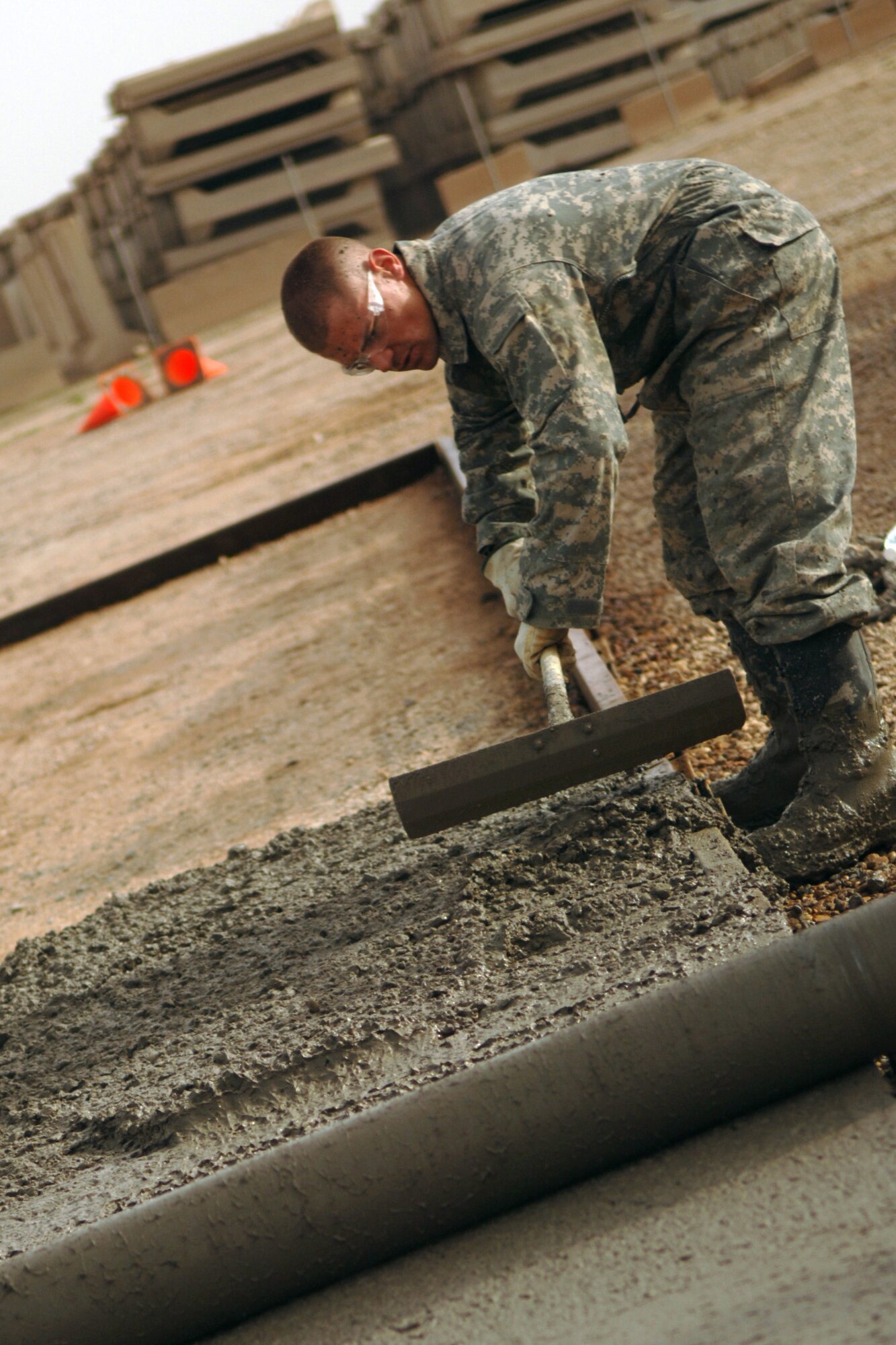 JOINT BASE BALAD, Iraq - Senior Airman James Smith, 332nd Expeditionary Civil Engineer Squadron pavement and construction equipment operator, evens out an area of concrete as part of a construction project here Feb. 15. Smith is deployed from Elmendorf Air Force Base, Alaska, and is a native of Geneva, N.Y. (U.S. Air Force photo/Staff Sgt. Dilia Ayala)