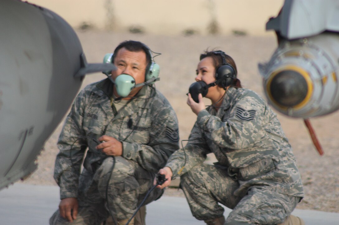 Tech. Sgt. Juan M. Guerra, 332nd Expeditionary Aircraft Maintenance Squadron crew chief, shows Tech. Sgt. Veronica Cardoza, 332nd Expeditionary Fighter Squadron, here Feb. 8 the steps and checks he has to accomplish to prepare and launch an F-16 Fighting Falcon. Both Airmen, currently deployed here from Homestead Air Reserve Base, Fl., are wearing headsets that have full communication with the pilot as they check all required technical-data items. The Airmen are from Homestead, Fl. (U.S. Air Force photo/Tech. Sgt. Lionel Castellano)