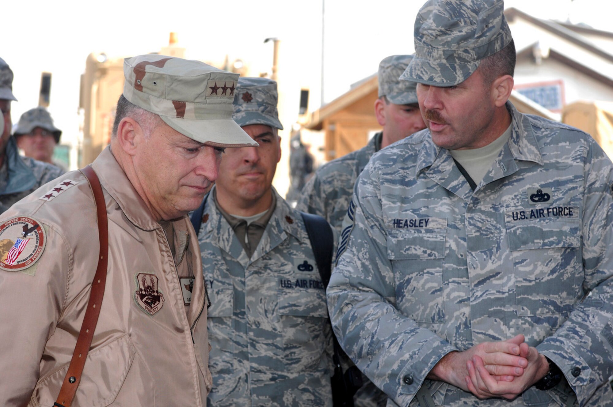Chief Master Sgt. John Heasley, from the 455th Expeditionary Aerial Port Squadron, briefs Lt. Gen. Gary North, 9th Air Force and U.S. Air Forces Central commander, about the details of the new unit recently stood up at Bagram Air Field, Afghanistan. The general traveled along with Chief Master Sgt. Scott Dearduff, 9th Air Force and U.S. Air Forces Central command chief master sergeant, and retired Lt. Gen. Eugene Santarelli, an Air Force senior mentor, to speak with hundreds of Bagram Airmen Feb. 17 about some of the challenges they will face in the coming months and thank Airmen who are nearing the end of their deployment rotation for their contribution to Operation Enduring Freedom and the Global War on Terrorism. (U.S. Air Force photo by Staff Sgt. Jason Lake)