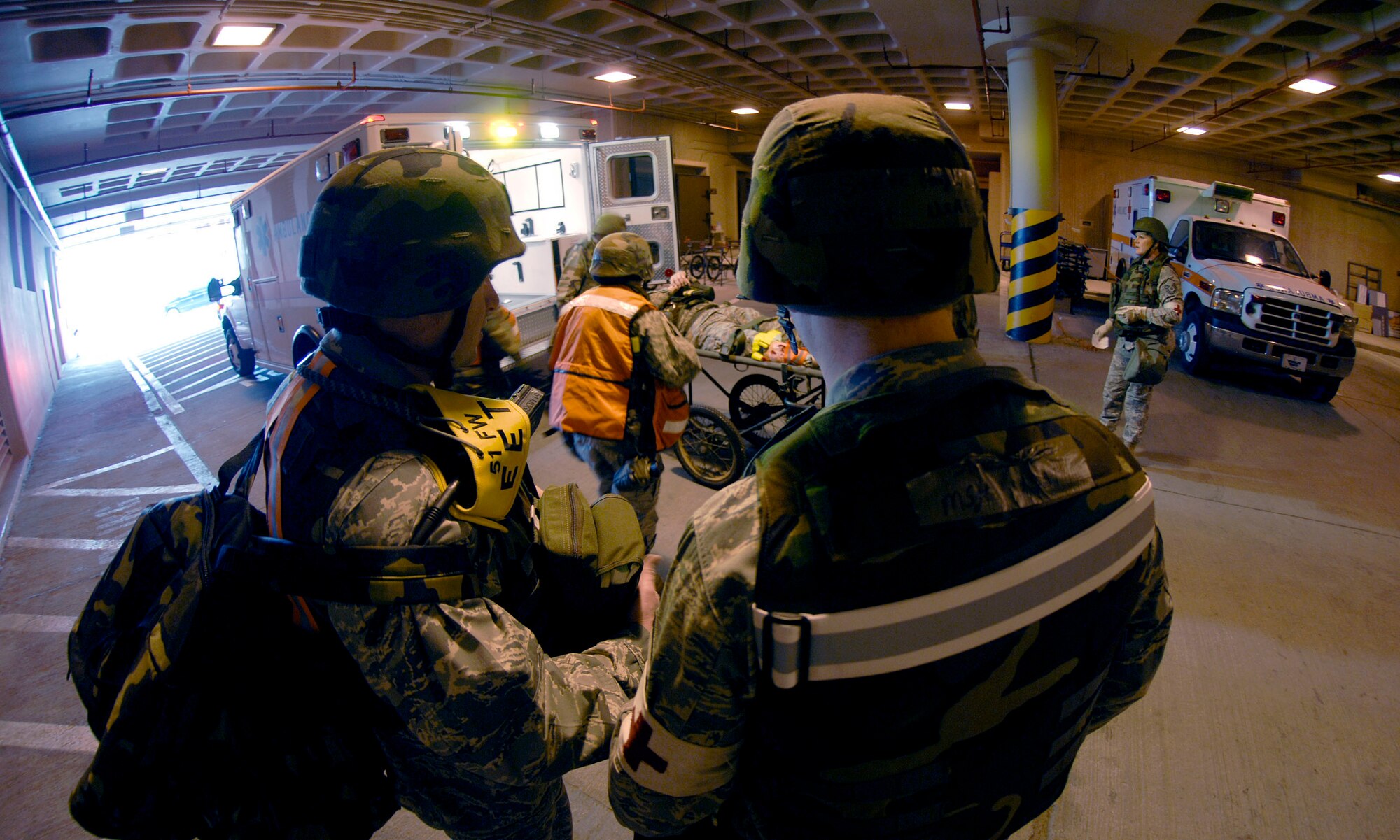 Exercise Evaluation Team members look on as Airmen from the 51st Medical Group unload Col. Thomas Deale at the base hospital to treat his simulated broken leg, sustained during a ?bug out? of the Emergency Operations Center Feb 09.  Col. Deale is the 51st FW Commander. (US Air Force photo by Staff Sgt. Brian Ferguson)