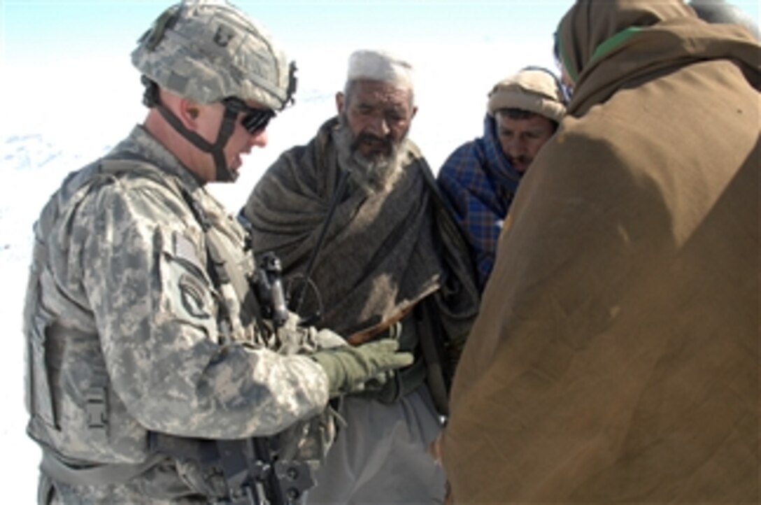 A U.S. Army soldier talks to Afghan elders in Bagram, Afghanistan, on Feb. 15, 2009.  