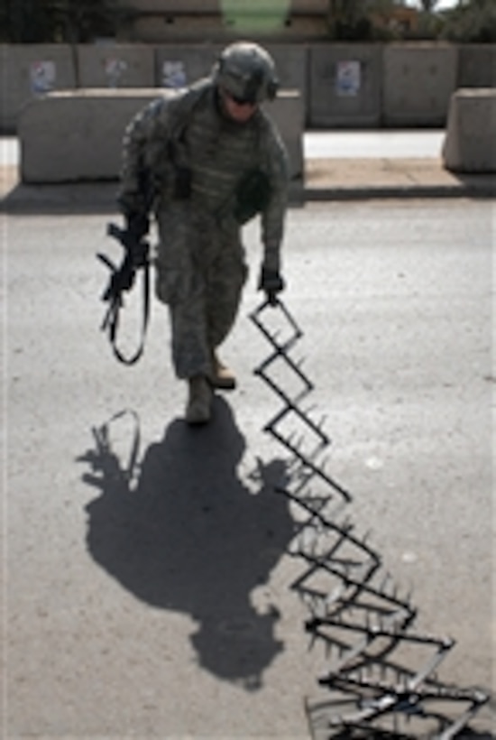 U.S. Army Pfc. Walters of the 2nd Brigade, 1st Infantry Division sets up a spike strip at a vehicle checkpoint in Ameriyah, Iraq, on Feb. 13, 2009.  