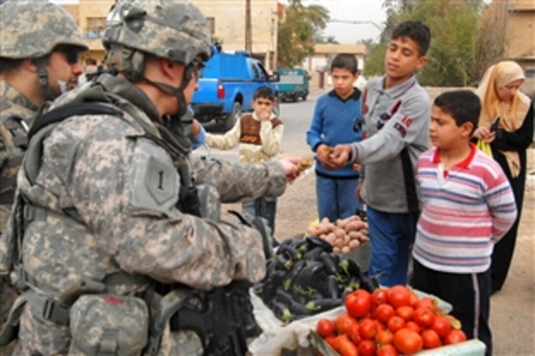 U.S. Army 1st Lt. Joshua Jones purchases some fruit from a local street merchant in Ameriyah, Iraq, Feb. 9, 2009. Jones is assigned to the 1st Infantry Division's 2nd Combat Brigade Team.