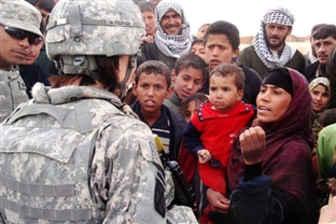 U.S. Army Capt. Jennifer Glossinger, coordinator for the Women’s Initiative, speaks with an Iraqi  woman about issues women face during a meeting near Baghdad, Iraq, Feb. 16, 2009. The program is designed to empower women and foster equality by ensuring basic human rights are met.