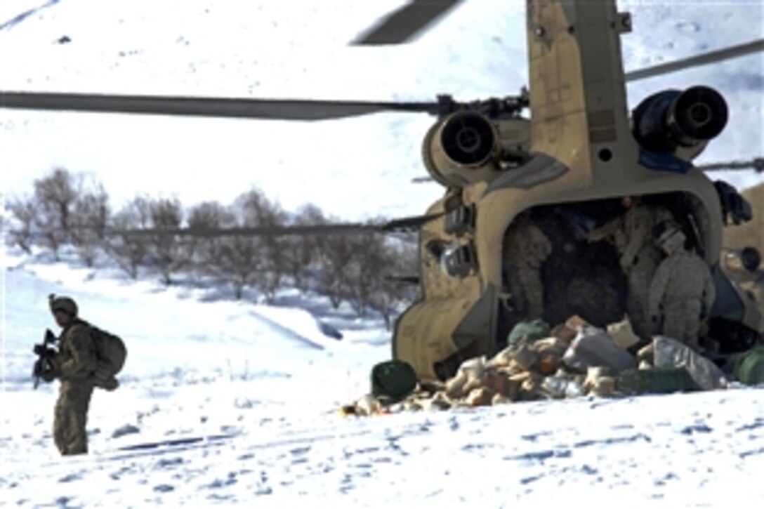 A U.S. Army soldier provides security as fellow soldiers from his unit unload supplies for a humanitarian mission from a CH-47 Chinook helicopter in Bagram, Afghanistan, Feb. 15, 2009.