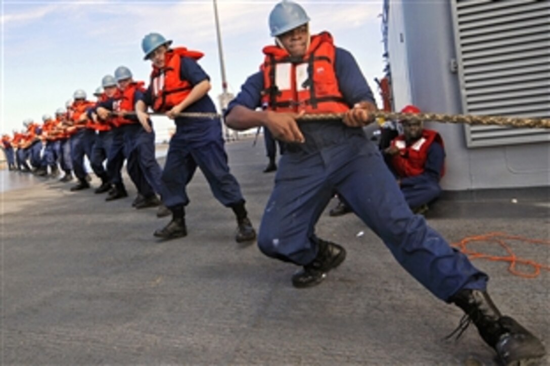 U.S. Navy Seaman Darrell Moore and other sailors heave a messenger line aboard the amphibious command ship USS Blue Ridge during an underway replenishment with the Military Sealift Command fleet replenishment oiler USNS Pecos in the Pacific Ocean, Feb. 17, 2009.