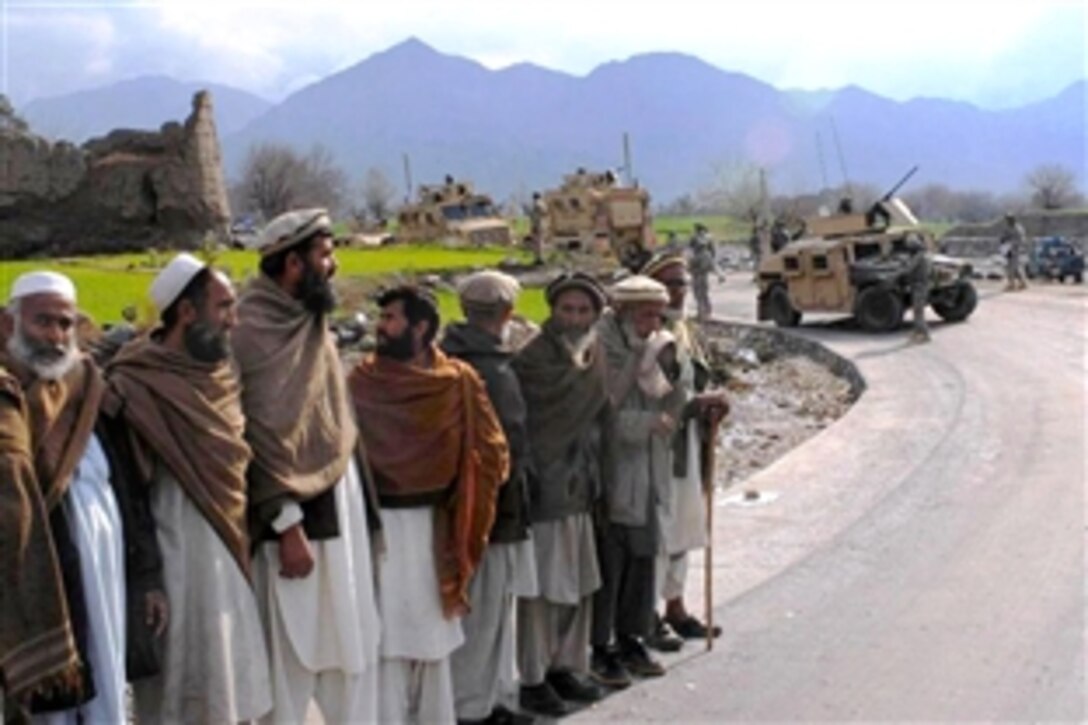 Villagers line a new road waiting for the local governor to arrive to officially open a paved road in the Deywagal Valley of Afghanistan’s Konar province, Feb. 6, 2009. The Konar Provincial Reconstruction Team and the 1st Infantry Division’s 3rd Brigade Combat Team spent two years building the seven-mile road, offering Afghans better access to hospitals, schools and markets.