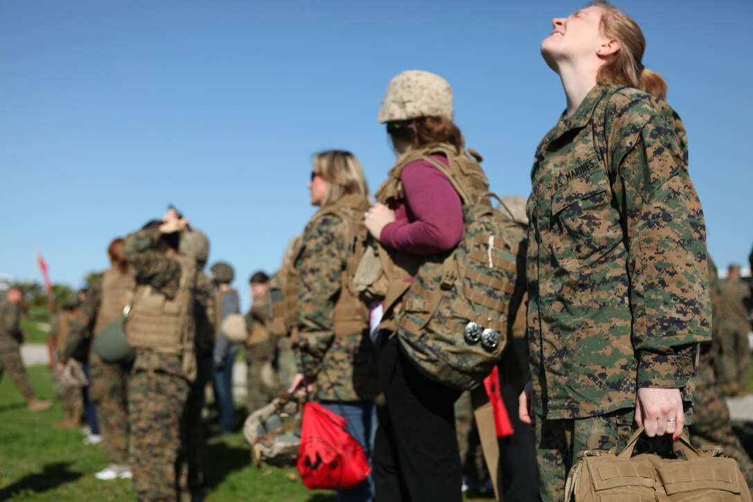 Sarah Alaia, wife of Sgt. Dylan Alaia, motor transport mechanic, Maintenance Battalion, Combat Logistics Regiment 15, 1st Marine Logistics Group, stretches her back after unloading all her gear during Jane Wayne day.