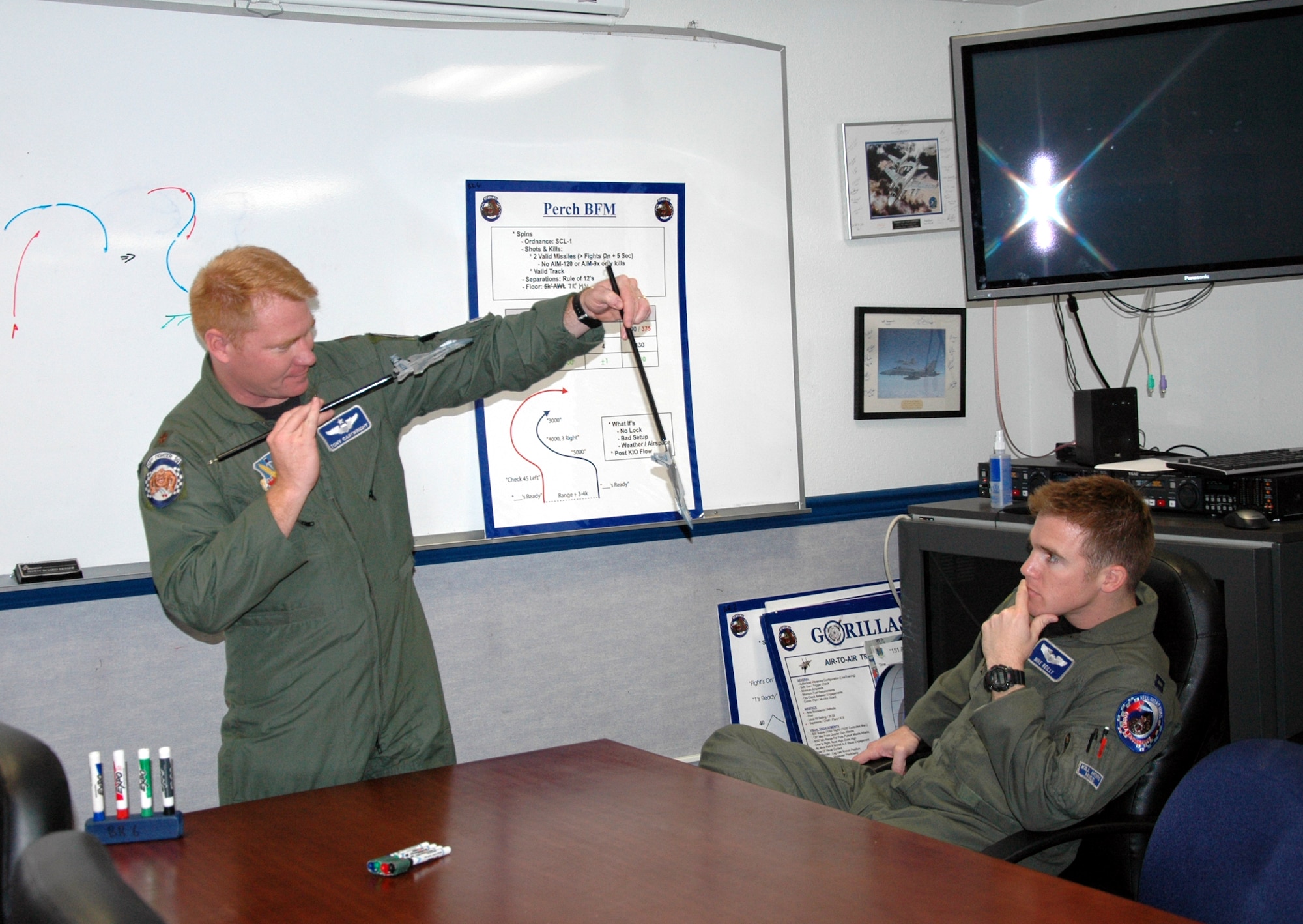 EGLIN AIR FORCE BASE, Fla. – Maj. Tony Cartwright, chief instructor pilot and weapons officer for the 58th Fighter Squadron, discusses air maneuvers in a debriefing room as Capt. Michael Reilly, 58th FS C Flight commander, listens. The 33rd Fighter Wing’s fighter pilots fly F-15C Eagles in air-to-air combat. (U.S. Air Force photo/Noel Getlin)
