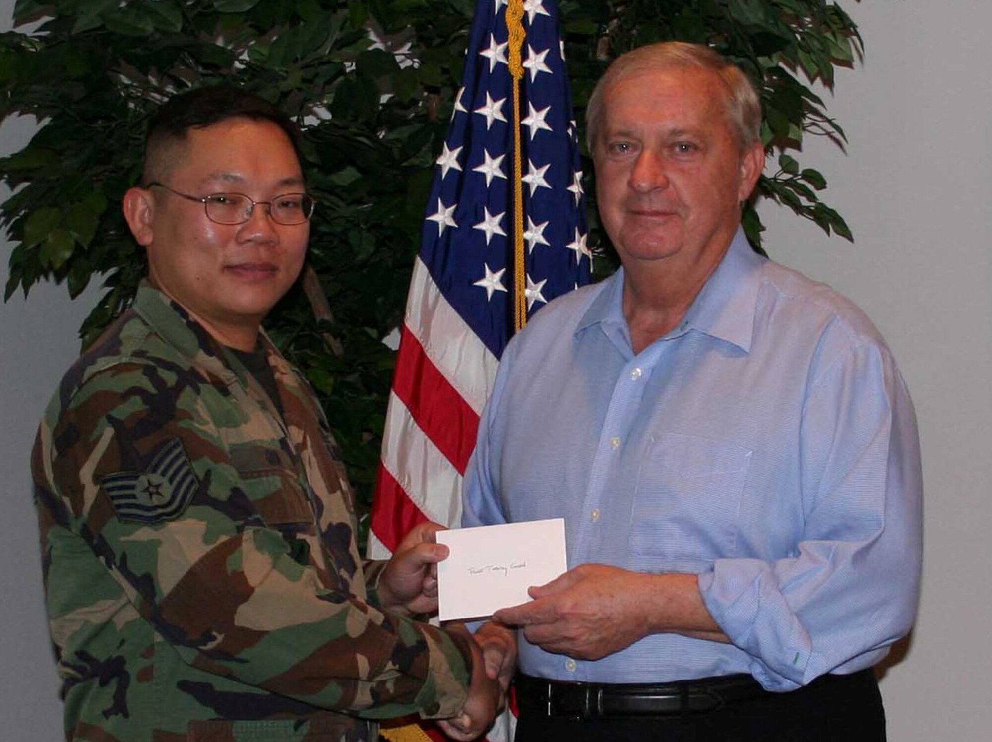 Tech. Sgt. Teddy Goon, 33rd Maintenance Operations Squadron, accepts a letter of appreciation and coin for his volunteer service at the Air Force Enlisted Village Feb. 11.  During the past three years, Sergeant Koon volunteered his time in the kitchen and serving meals to the men and women who live in the village.  (Courtesy photo.)