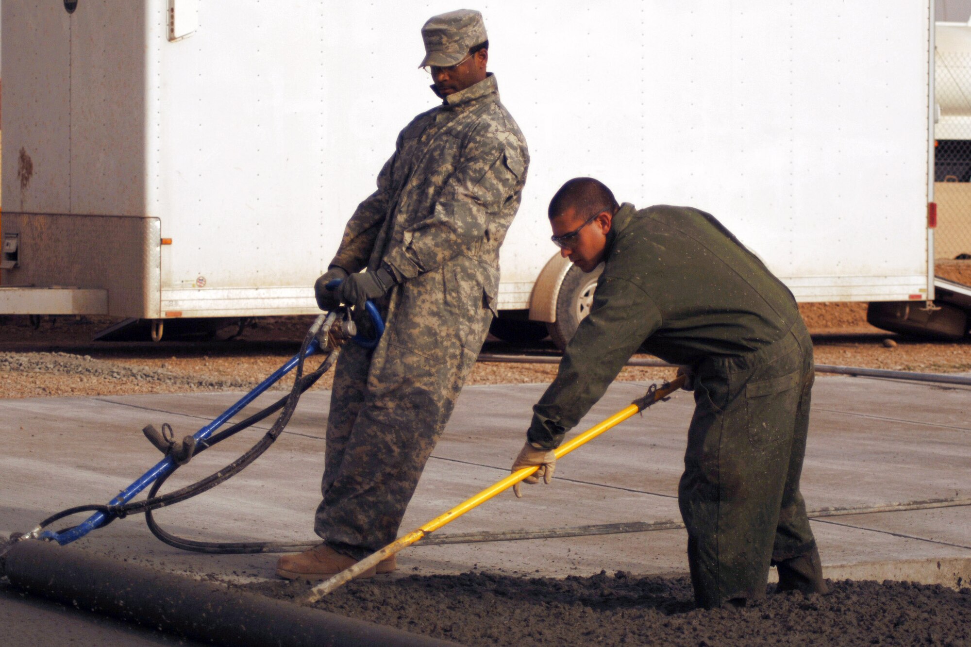 Staff Sgts. Dedrick Elder and Alexander Perez complete the last portion of a 76-meter concrete pad Feb. 15 during a construction project at Joint Base Balad, Iraq.  The NCOs are pavement and construction equipment operators with the 332nd Expeditionary Civil Engineer Squadron.  Sergeant Elder, a native of Knoxville, Tenn., is deployed from Little Rock Air Force Base, Ark., and Sergeant Perez, from Miami, is deployed from Eglin AFB, Fla. (U.S. Air Force photo/Staff Sgt. Dilia Ayala) 