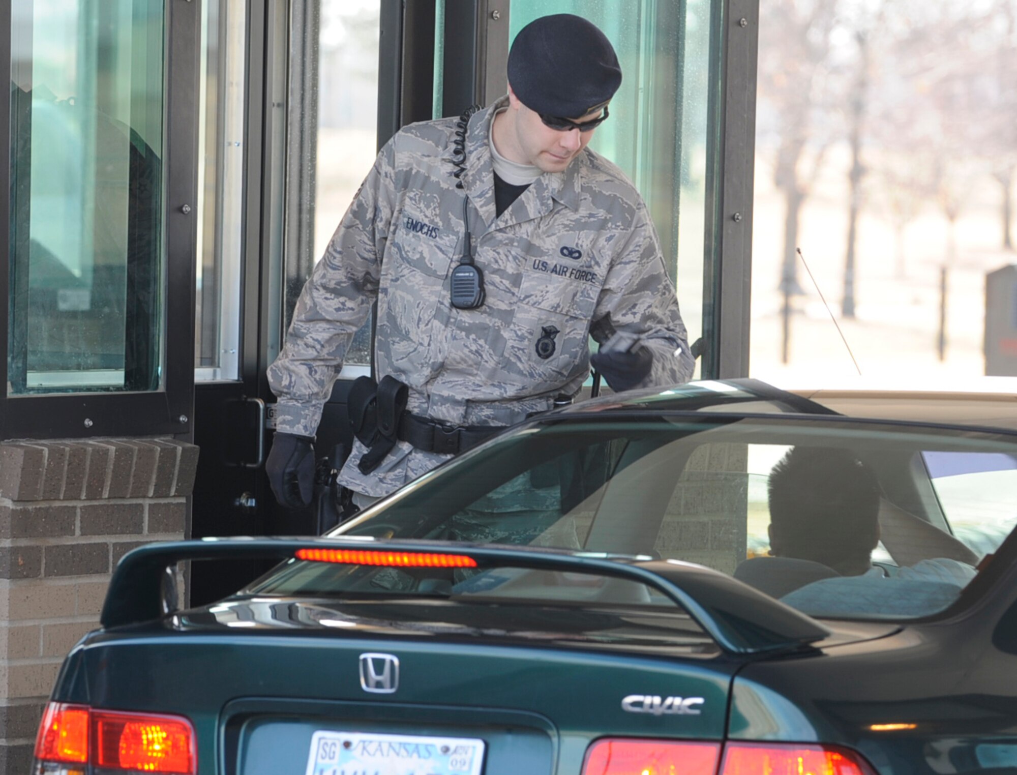 Senior Airman Bradley Enochs checks the identification of a driver entering McConnell Air Force Base, Kan. Airman Enochs is a security forces member of the 931st Air Refueling Group, an Air Force Reserve unit at McConnell. More than two dozen security forces personnell are expected to join the 931st in the next year. (U.S. Air Force photo/Tech. Sgt. Jason Schaap) 