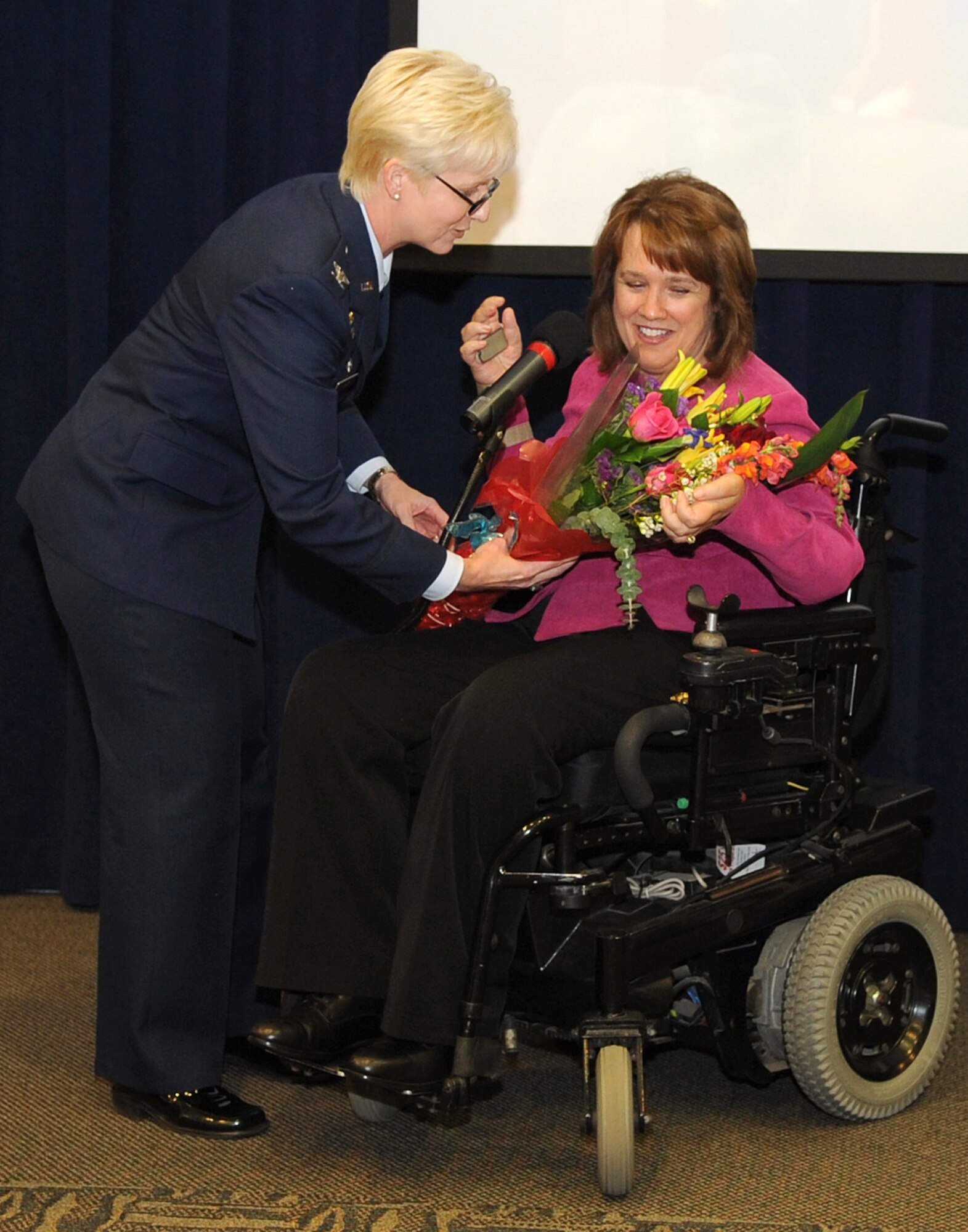 Col. Anita Latin, Los Angeles AFB Air Base Wing commander, presents keynote speaker Ms. Renée Bondi with a bouquet during her closing remarks at the 2009 National Prayer Breakfast held at the Gordon Conference Center, Feb. 11.  Ms. Bondi shared her life’s story and her faith in God in an upbeat and inspiring speech to a crowd of more than 230 attendees. (Photo by Stephen Schester)