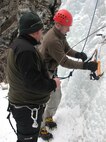 Ryan Murphy, Outdoor Recreation Connection staff member, provides Willie Golden, 22nd Training Squadron survival, evasion, resistance and escape specialist and a participant in the Outdoor Recreation Connection ice climbing trip, with a few pointers before he ascends a vertical frozen sheet of ice during a Valentine’s Day ORC ice climbing trip. (U.S. Air Force Photo / Senior Airman Kali L. Gradishar)